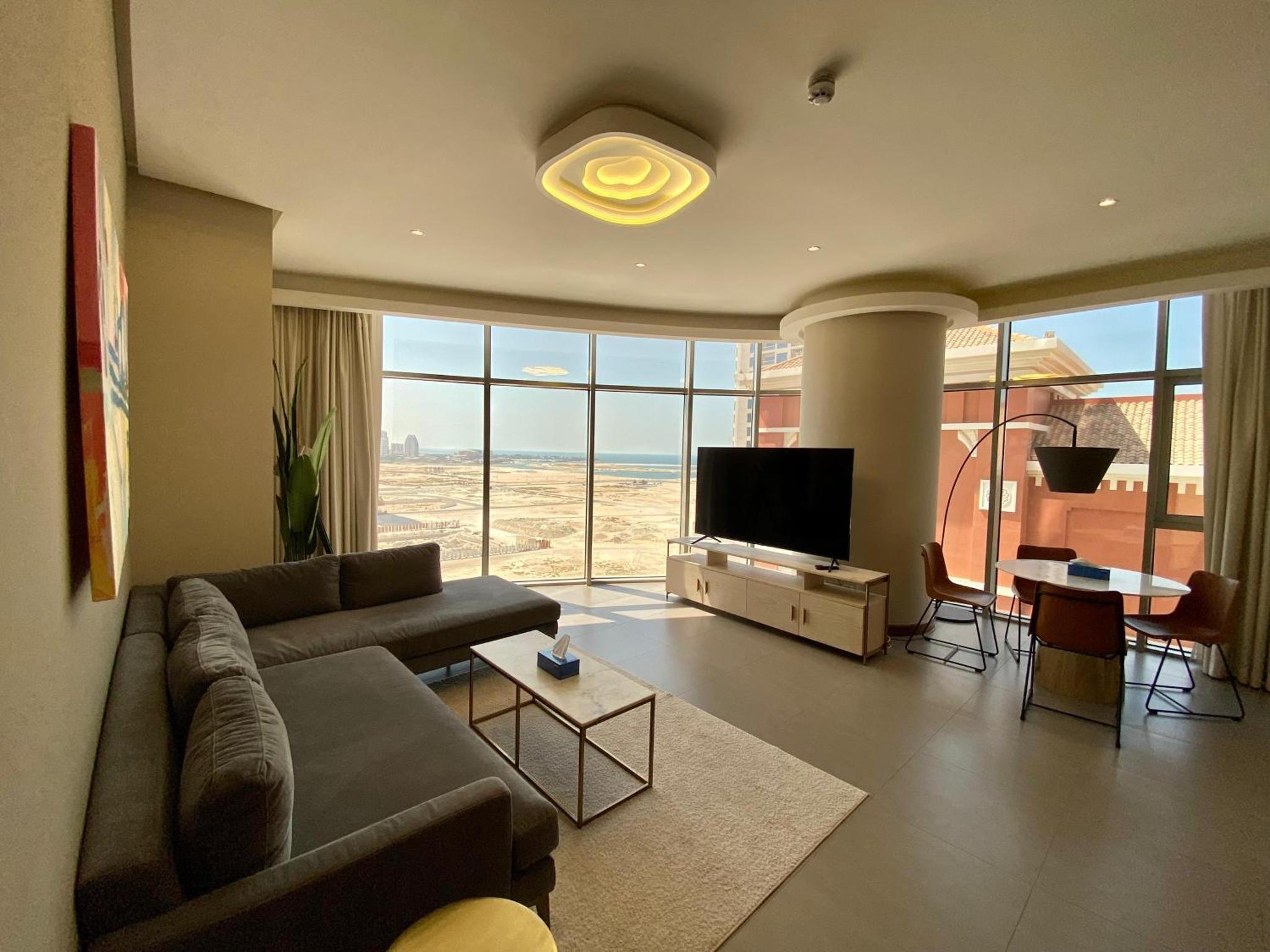 a living room with a couch and a flat screen tv at Seef Serenity - Sea & City Views in Manama