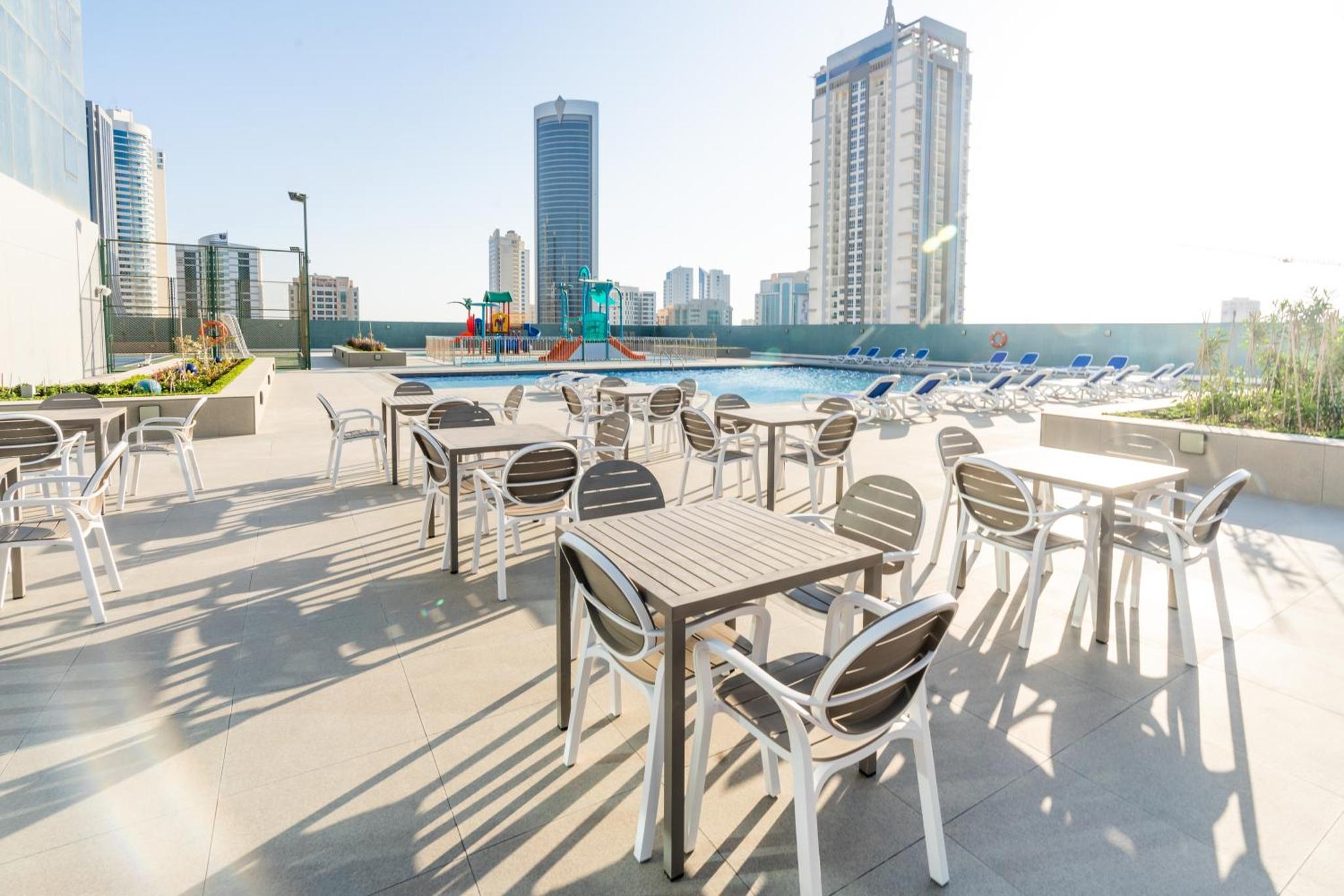 a row of tables and chairs on the roof of a building at S Plaza Suites Hotel in Manama