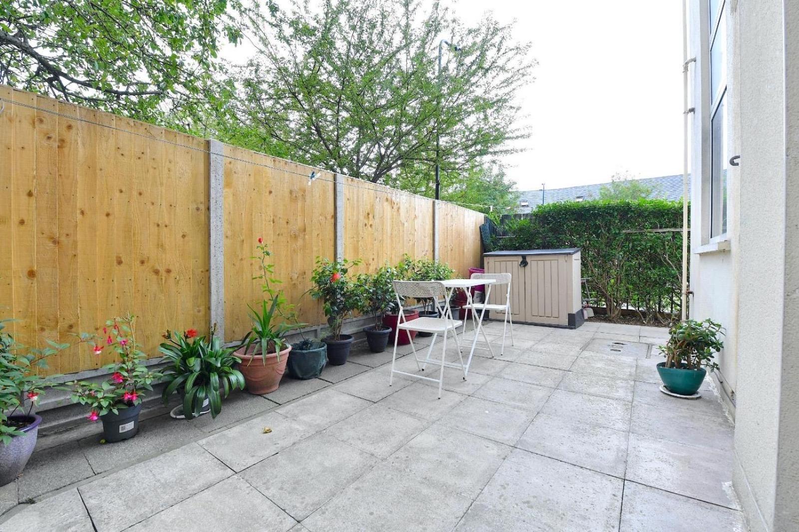 a patio with a table and chairs and potted plants at Central London 2 bedrooms apartment sleep 6 Free parking in London