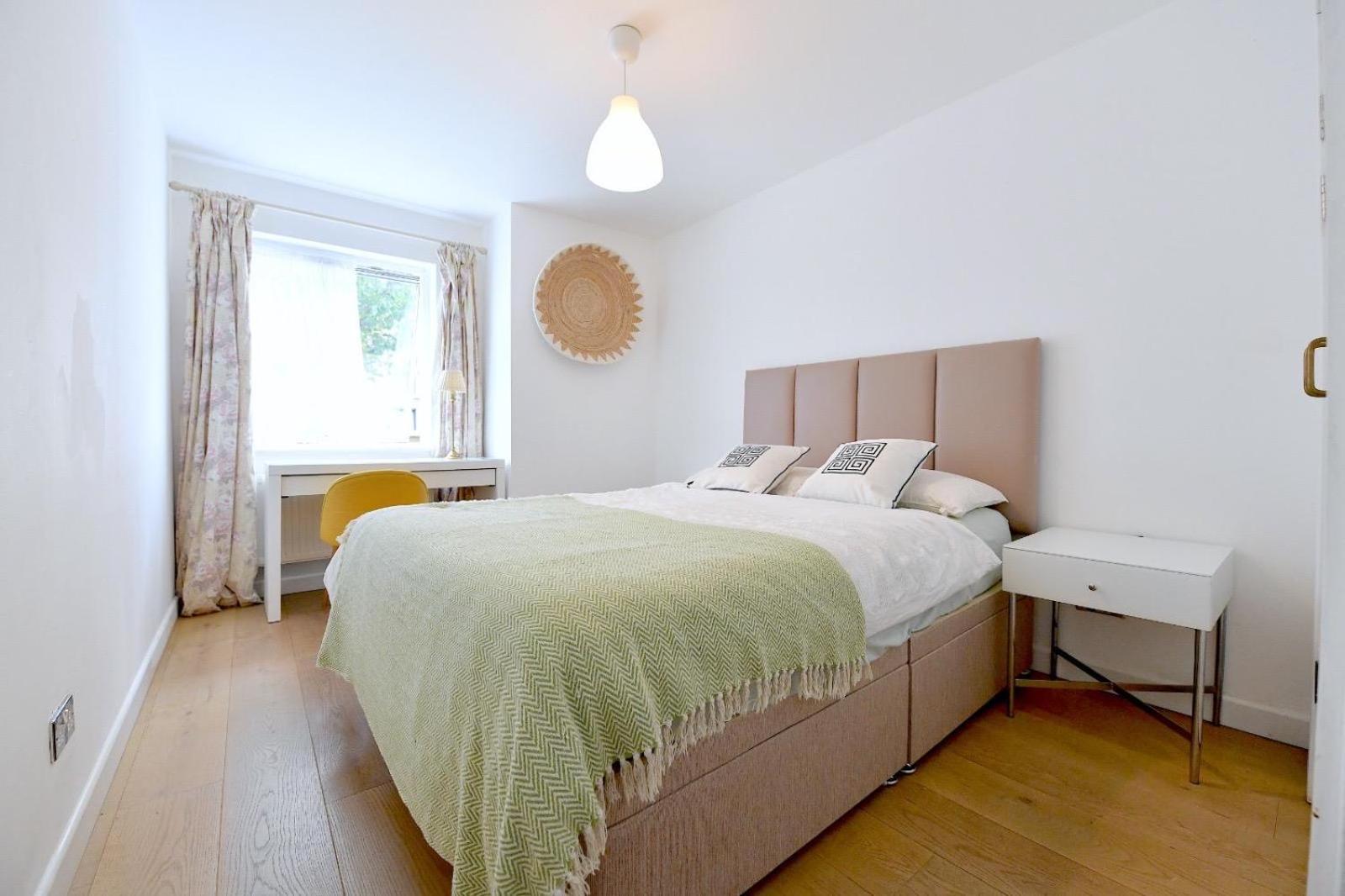 a white bedroom with a large bed and a window at Central London 2 bedrooms apartment sleep 6 Free parking in London