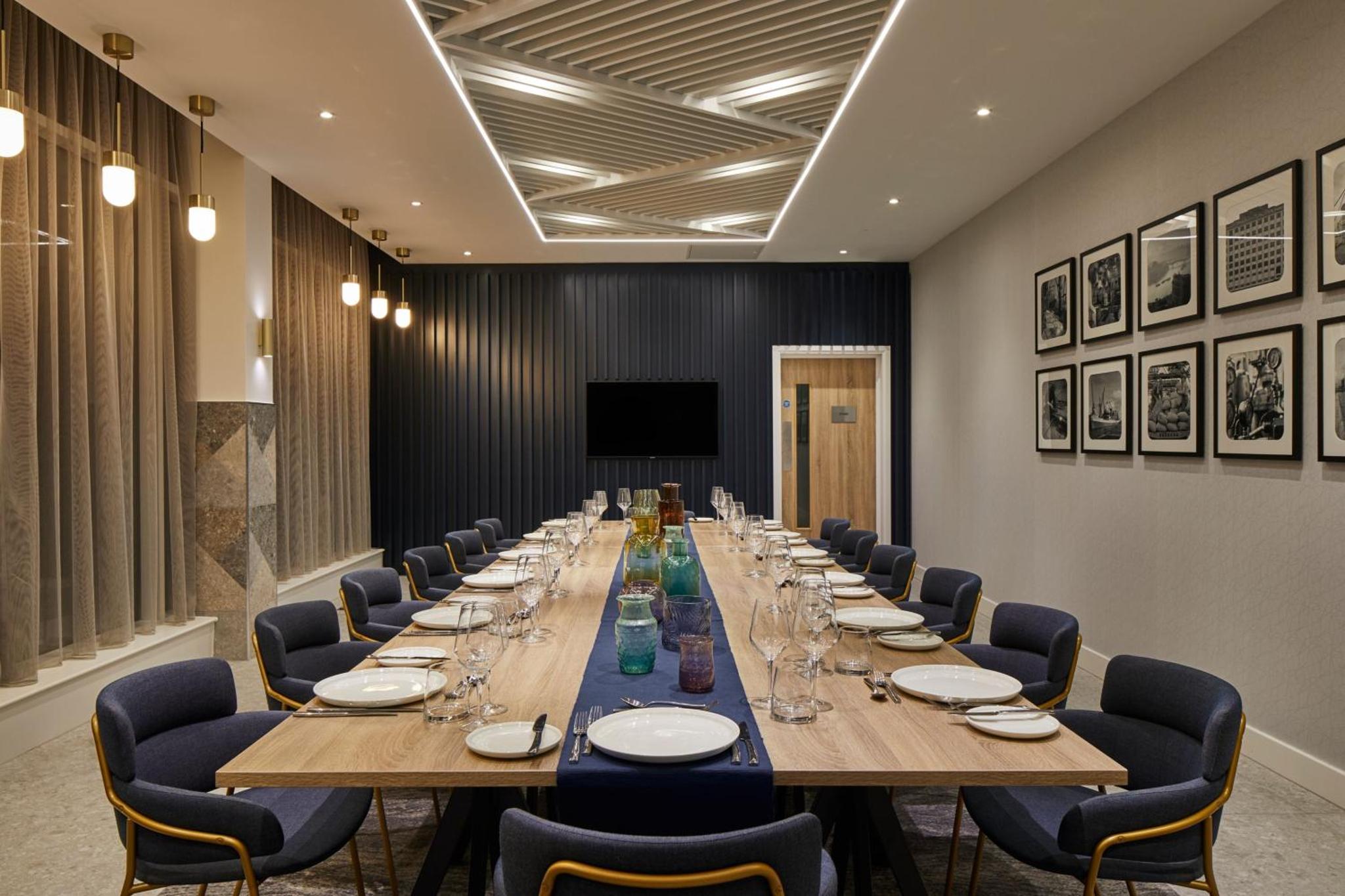 a large conference room with a long table and chairs at Courtyard by Marriott London City Airport in London