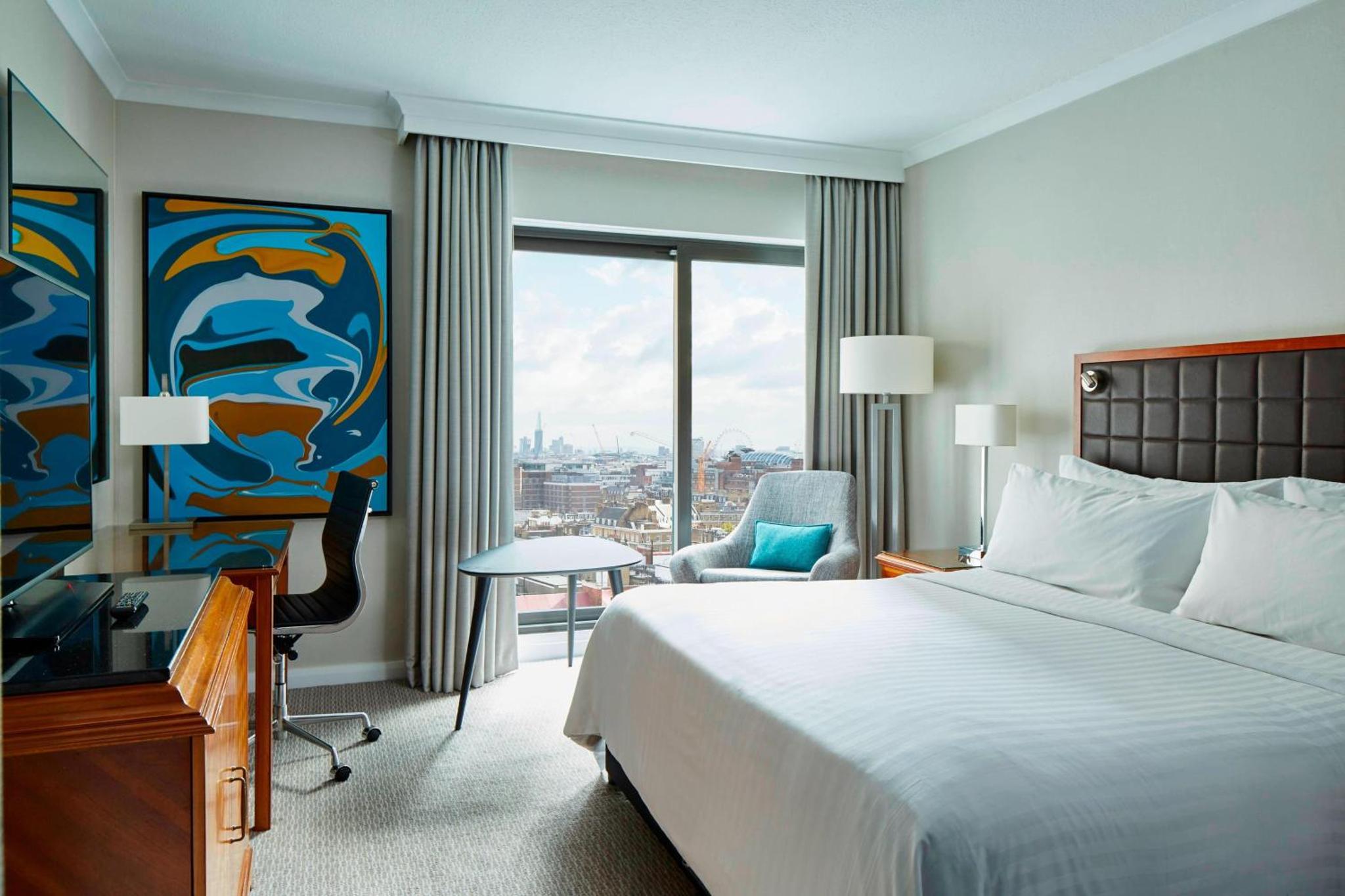 a hotel room with a bed and a desk and a window at London Marriott Hotel Marble Arch in London
