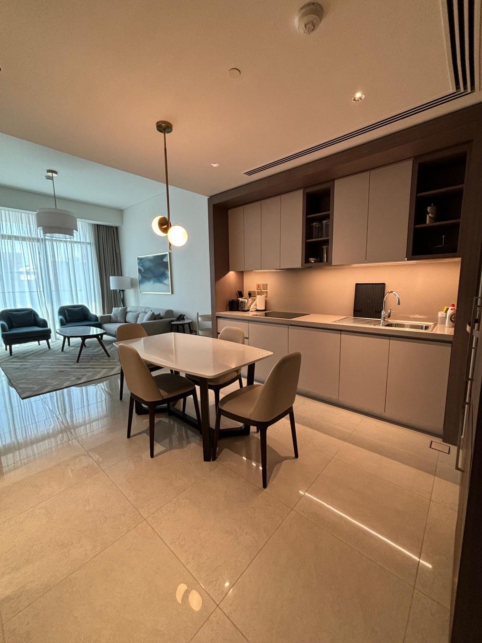 a kitchen and dining room with a table and chairs at Address Beach Resort Residence - Bahrain in Rayyā