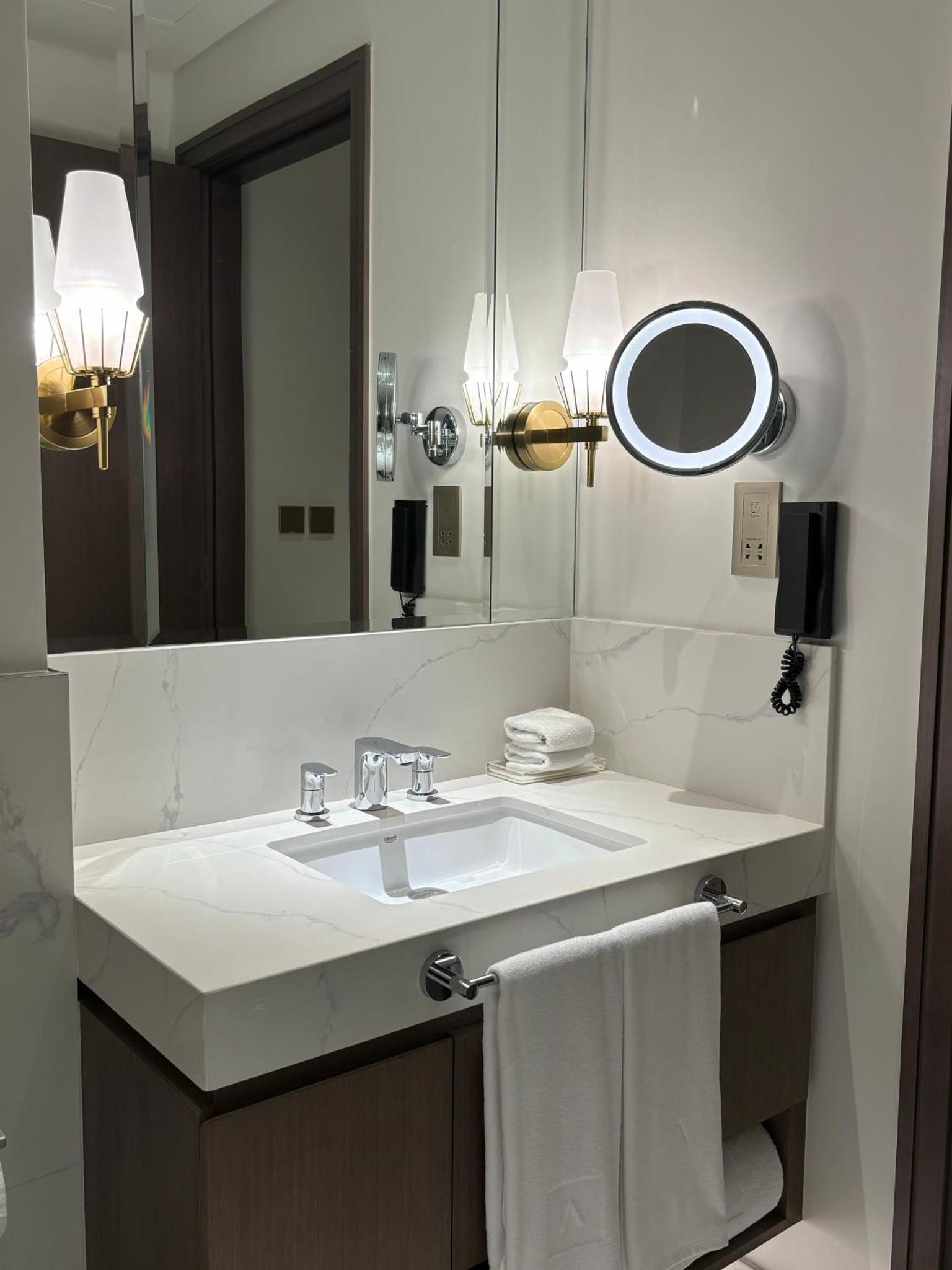 a bathroom with a white sink and a mirror at Address Beach Resort Residence - Bahrain in Rayyā