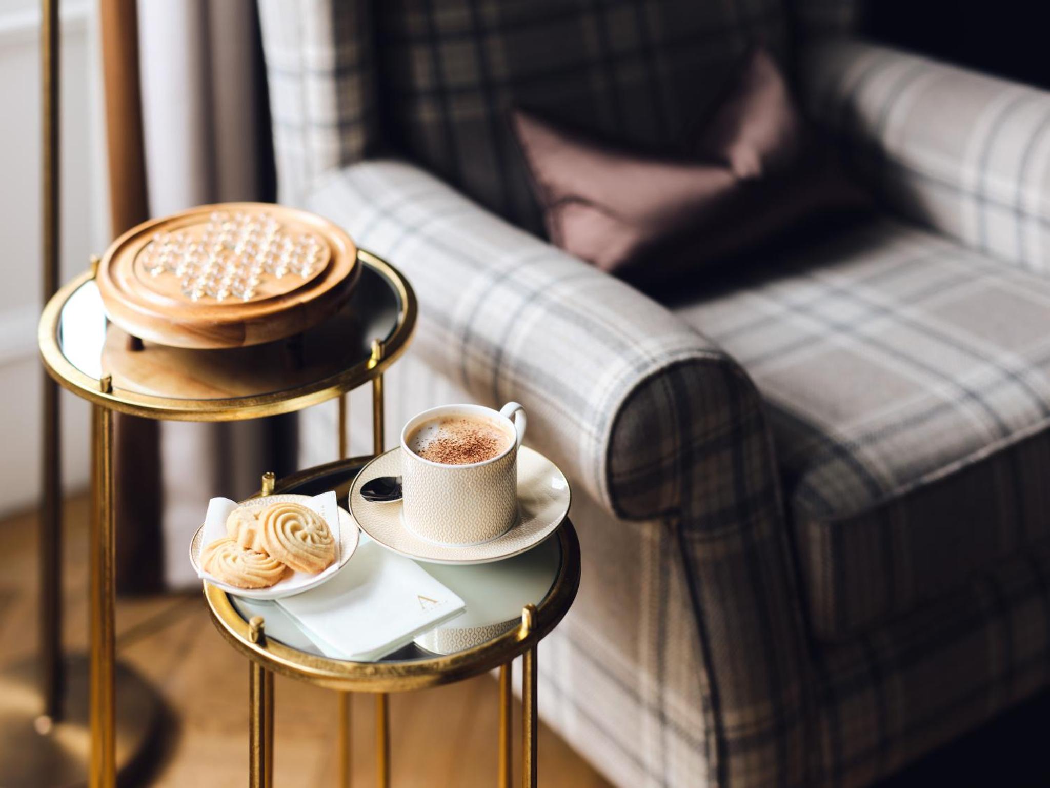 a couple of cups of coffee on a table with a couch at The Adria in London