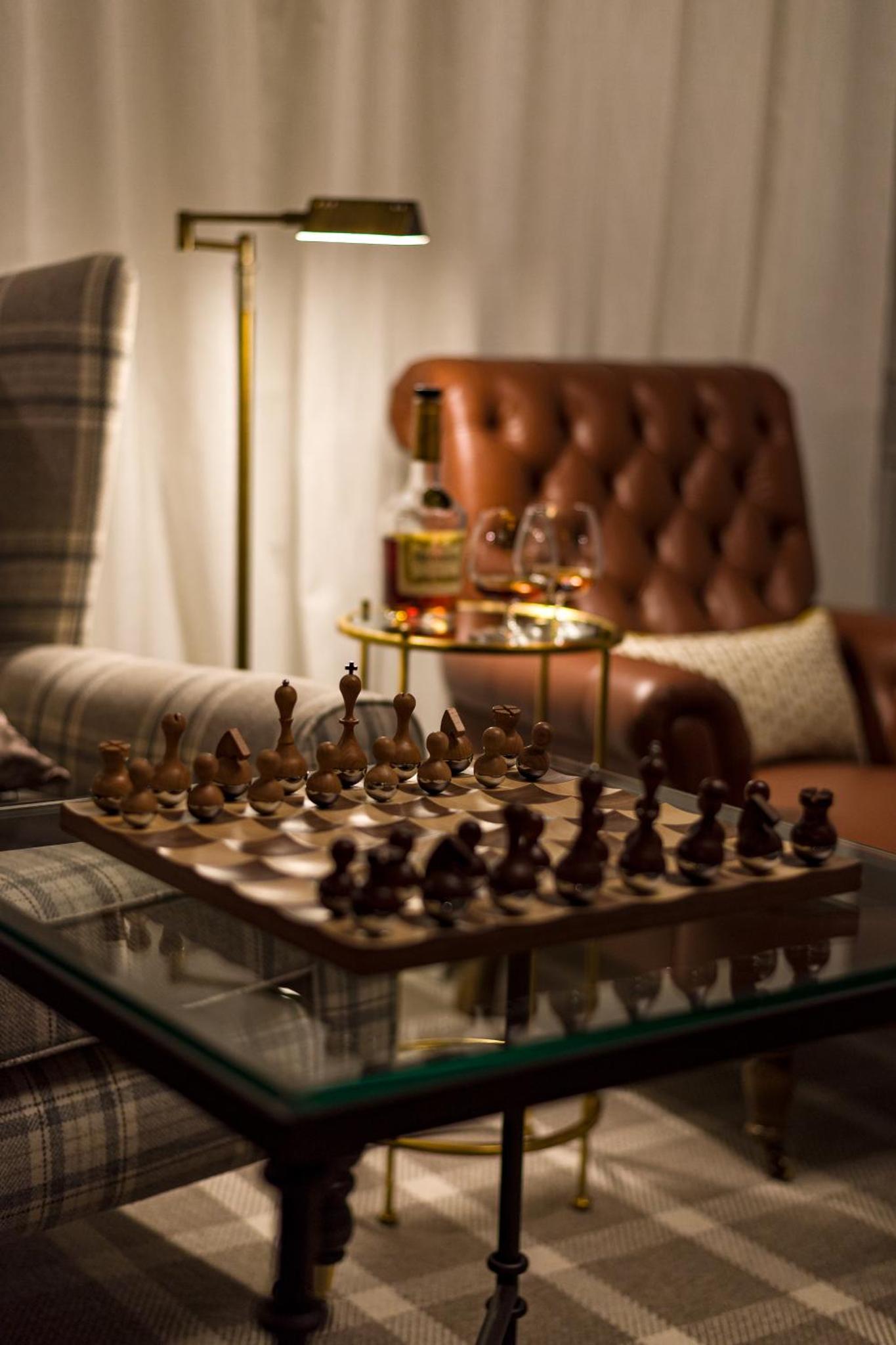 a chess board on a glass table in a living room at The Adria in London