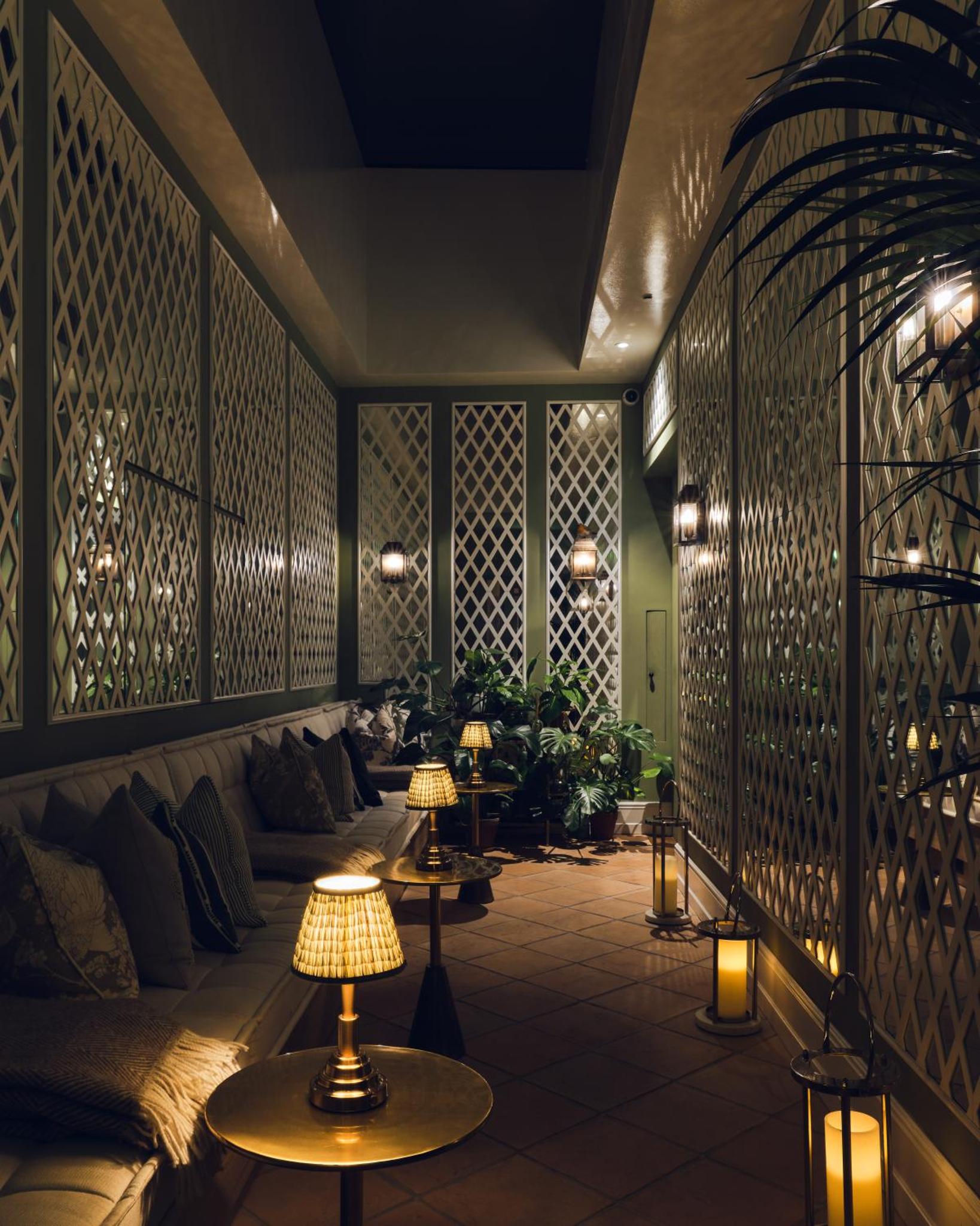 a room with lamps on a patio at night at The Adria in London