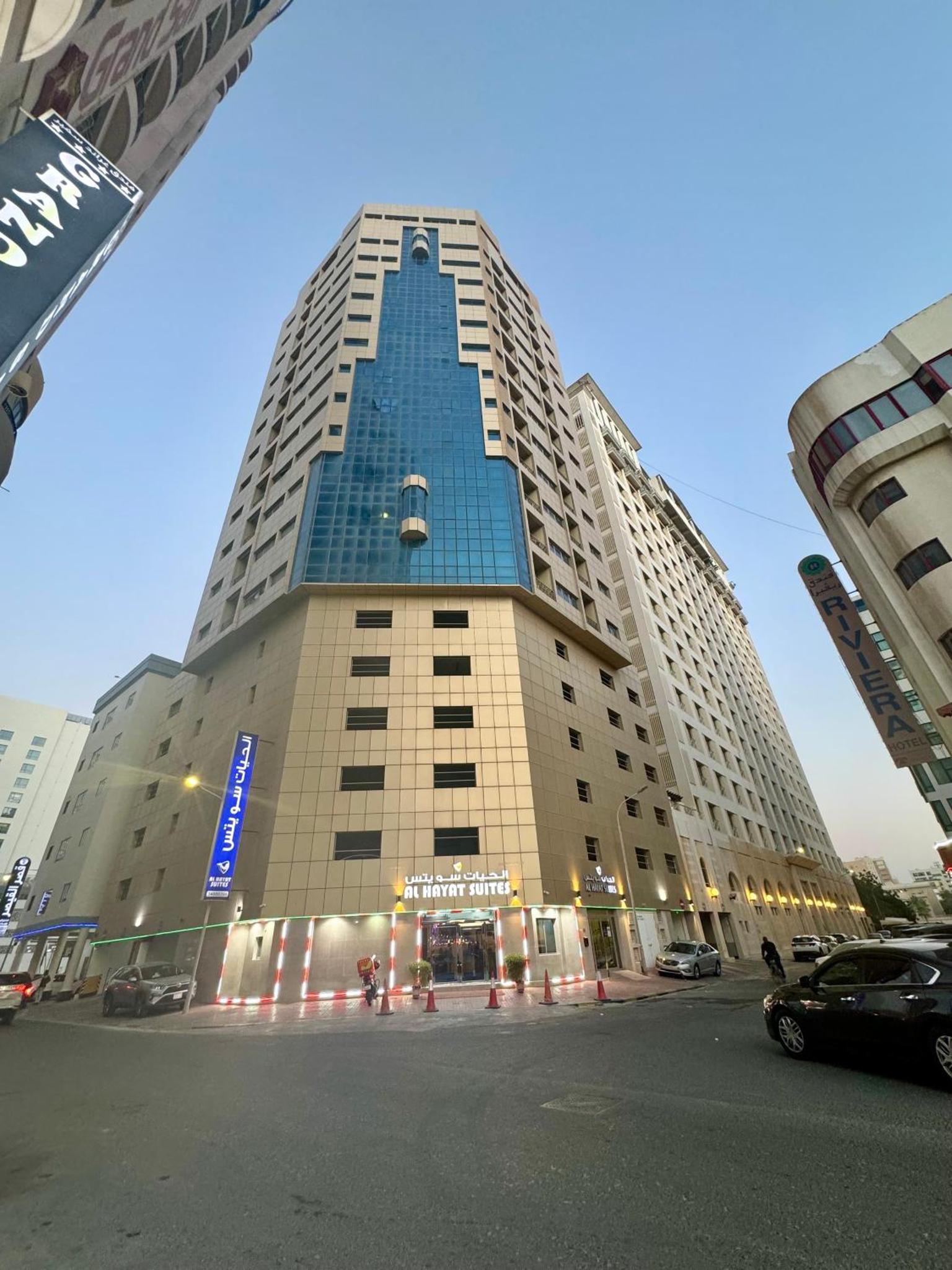 a tall building with a blue facade at Al Hayat Suites Apartment in Manama