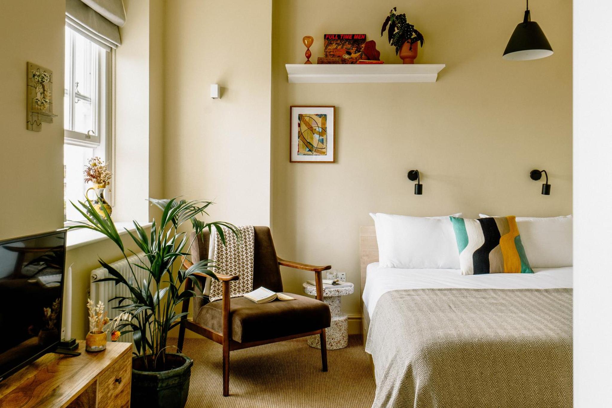 a hotel room with a bed and a chair at Mason & Fifth, Primrose Hill in London