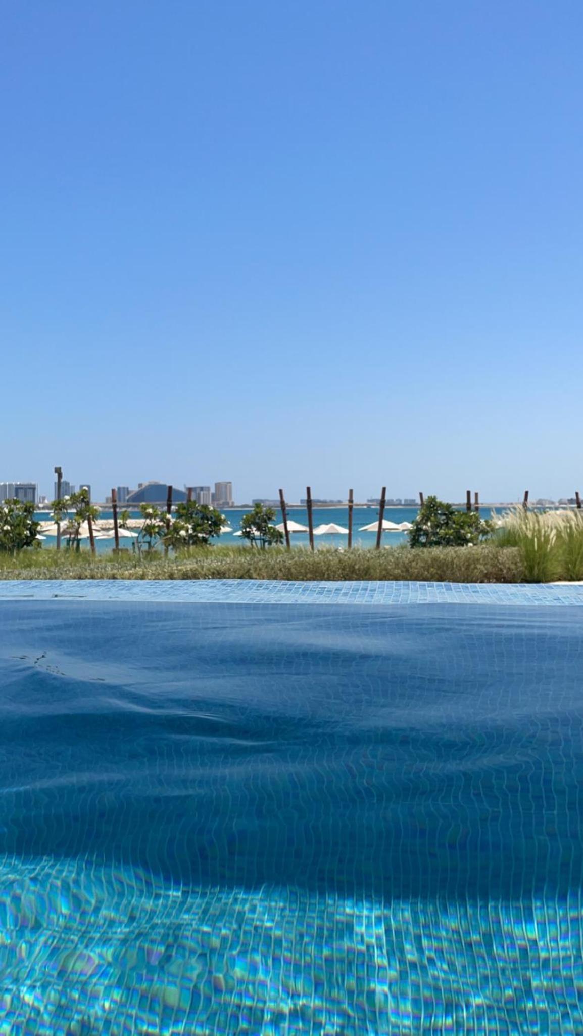 a pool of water with a view of the beach at Address Beach Resort Residence - Bahrain in Rayyā