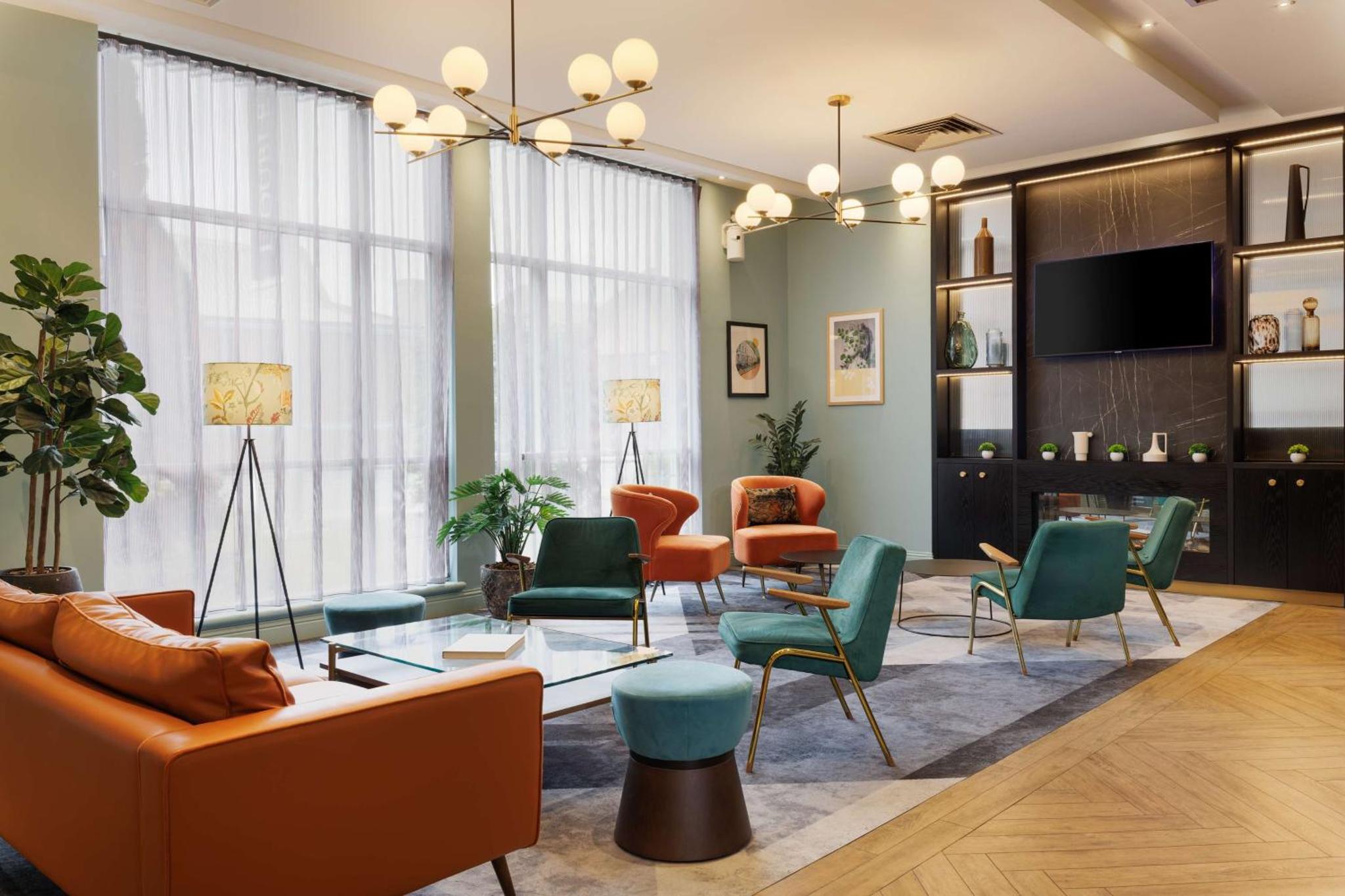 a living room with a couch and chairs at DoubleTree by Hilton London Chelsea in London