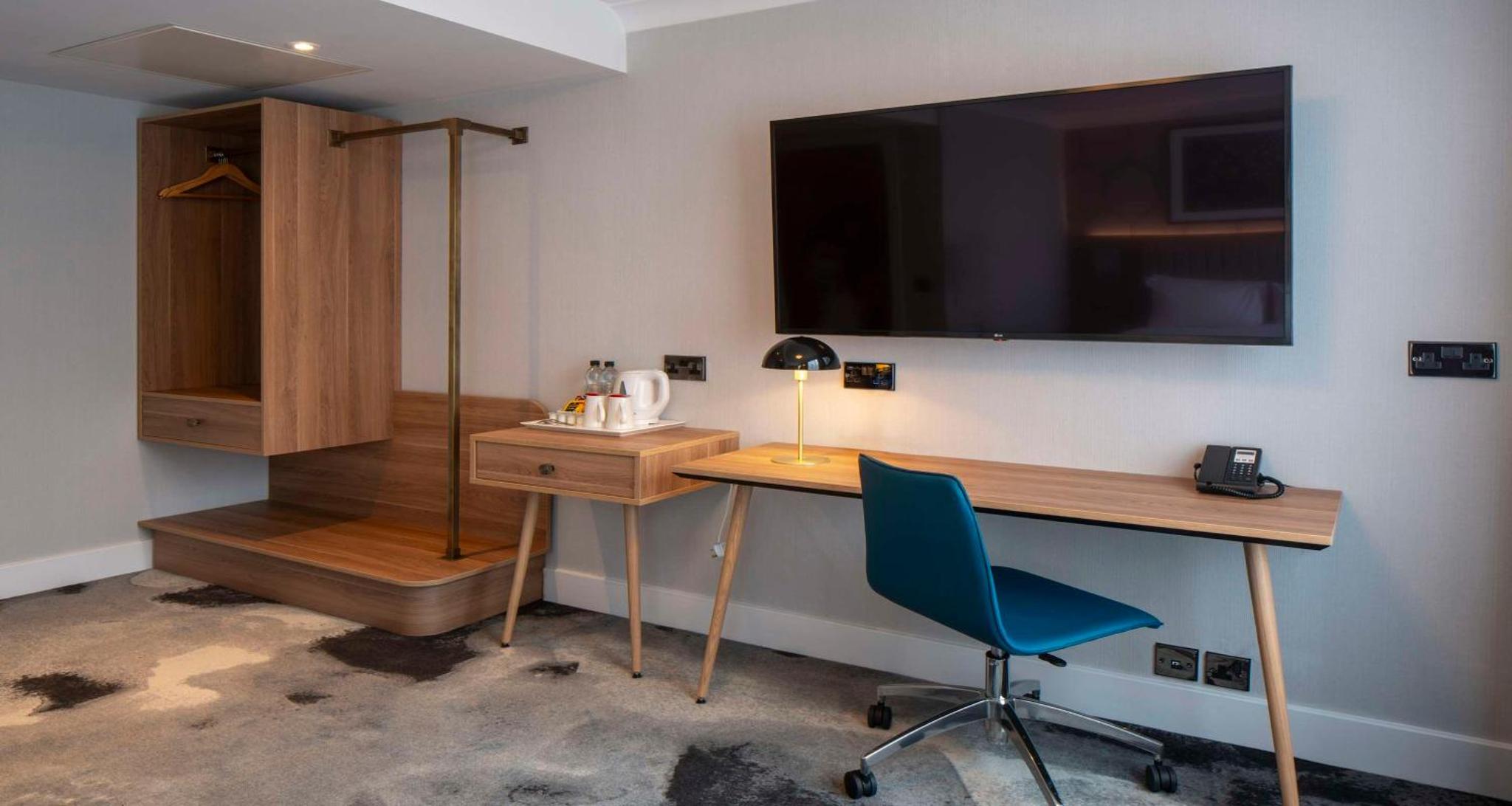 a room with a desk and a chair and a television at London Chigwell Prince Regent Hotel, BW Signature Collection in London