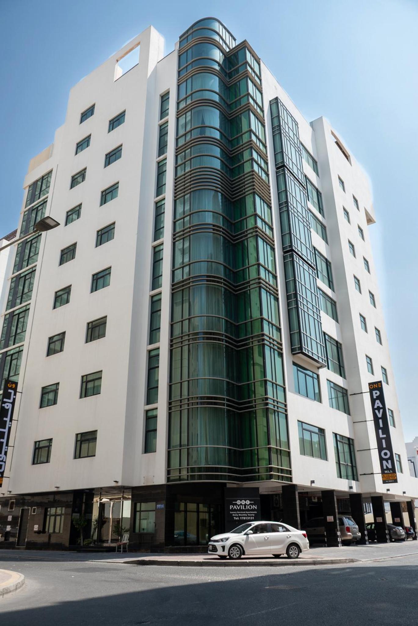 a white car parked in front of a building at One Pavilion Luxury Serviced Apartments in Manama