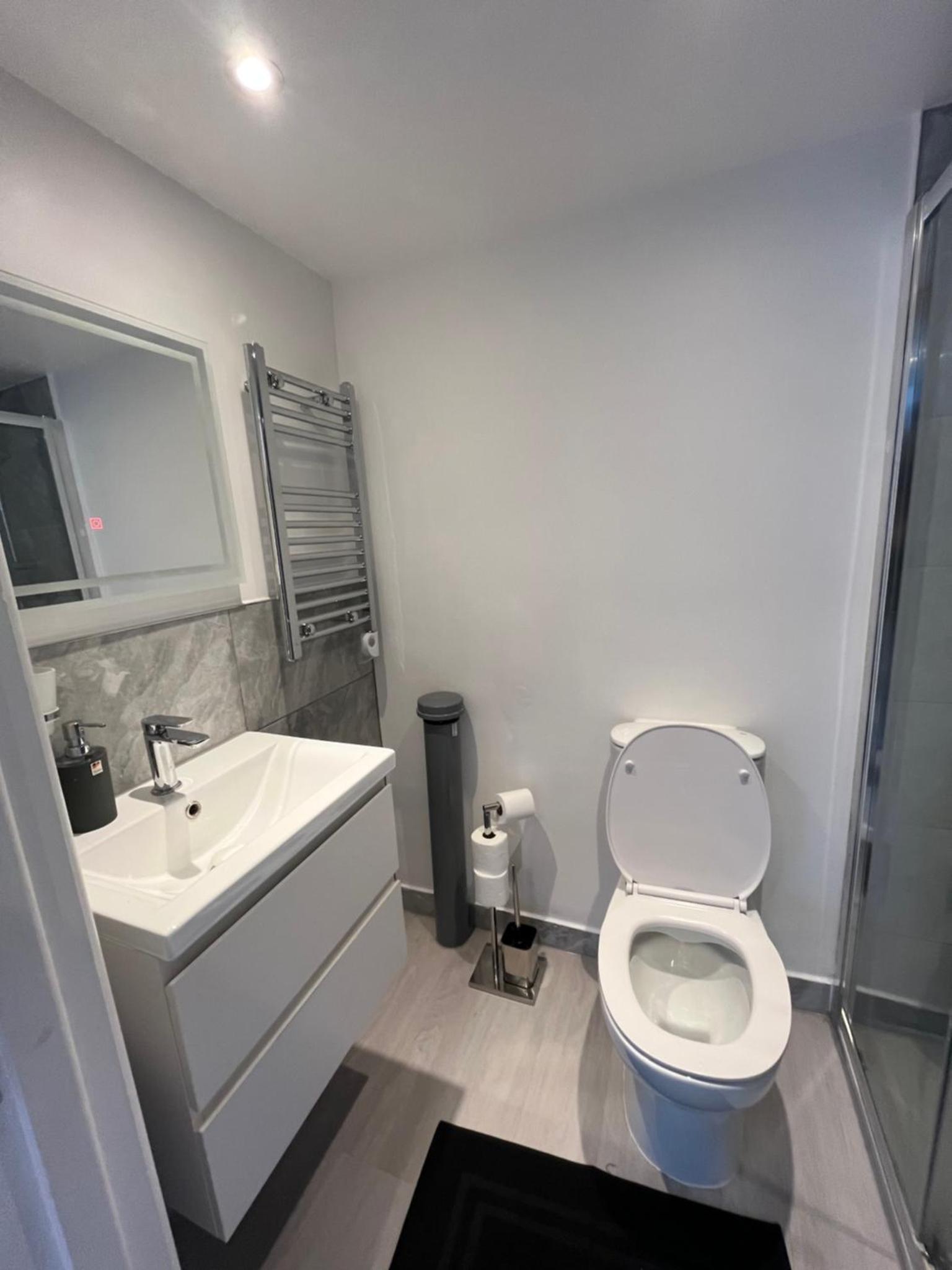 a bathroom with a white toilet and a sink at Camden BNB in London