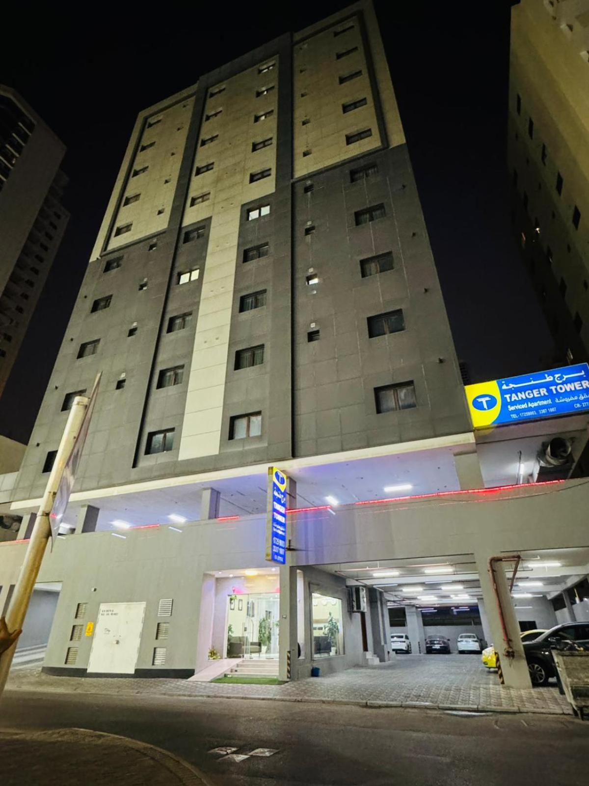 a tall building with a gas station in front of it at Tanger Tower in Manama