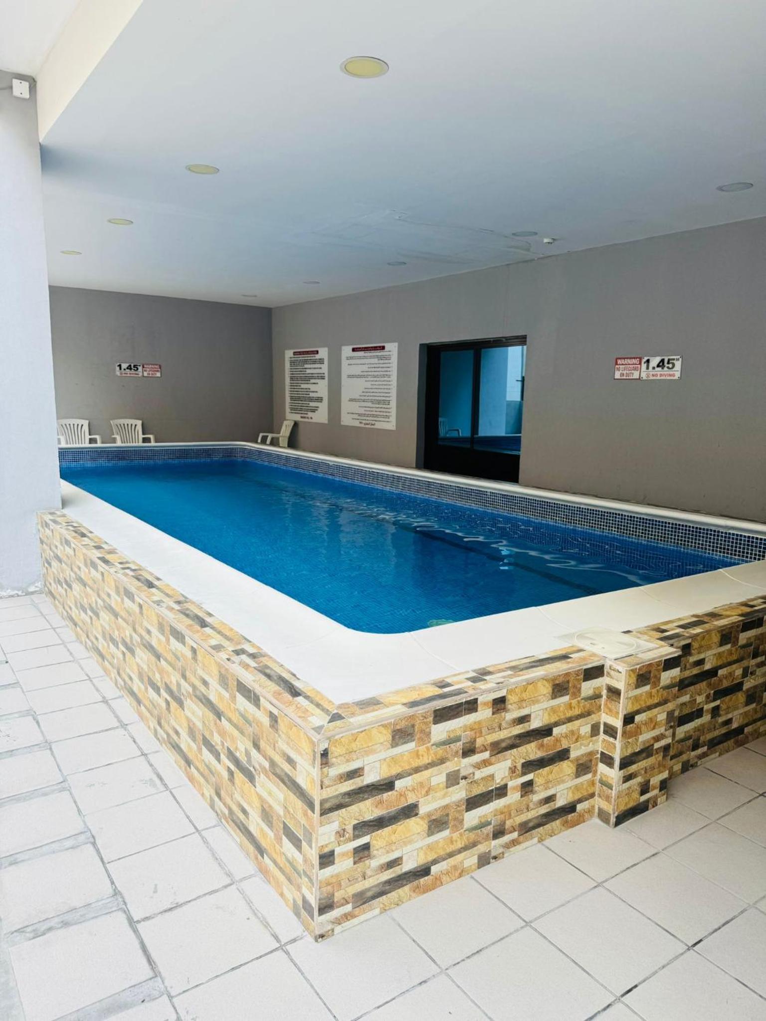 a large swimming pool in a hotel room at Tanger Tower in Manama