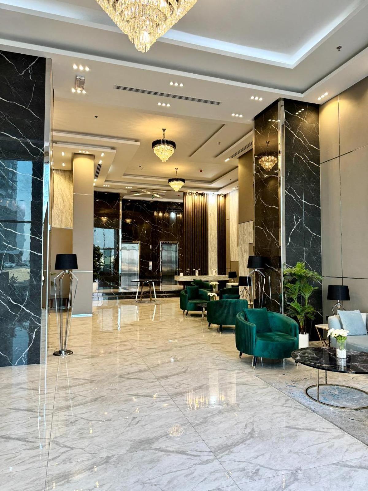a lobby of a hotel with green chairs at Al Safwa 2 in Manama +69 photos