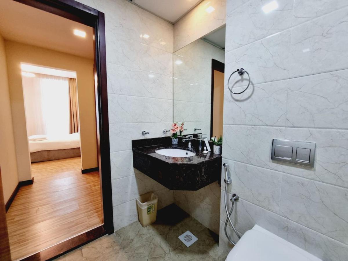 a bathroom with a sink and a toilet and a mirror at Aspire Tower-Travelers Trove Juffair in Manama