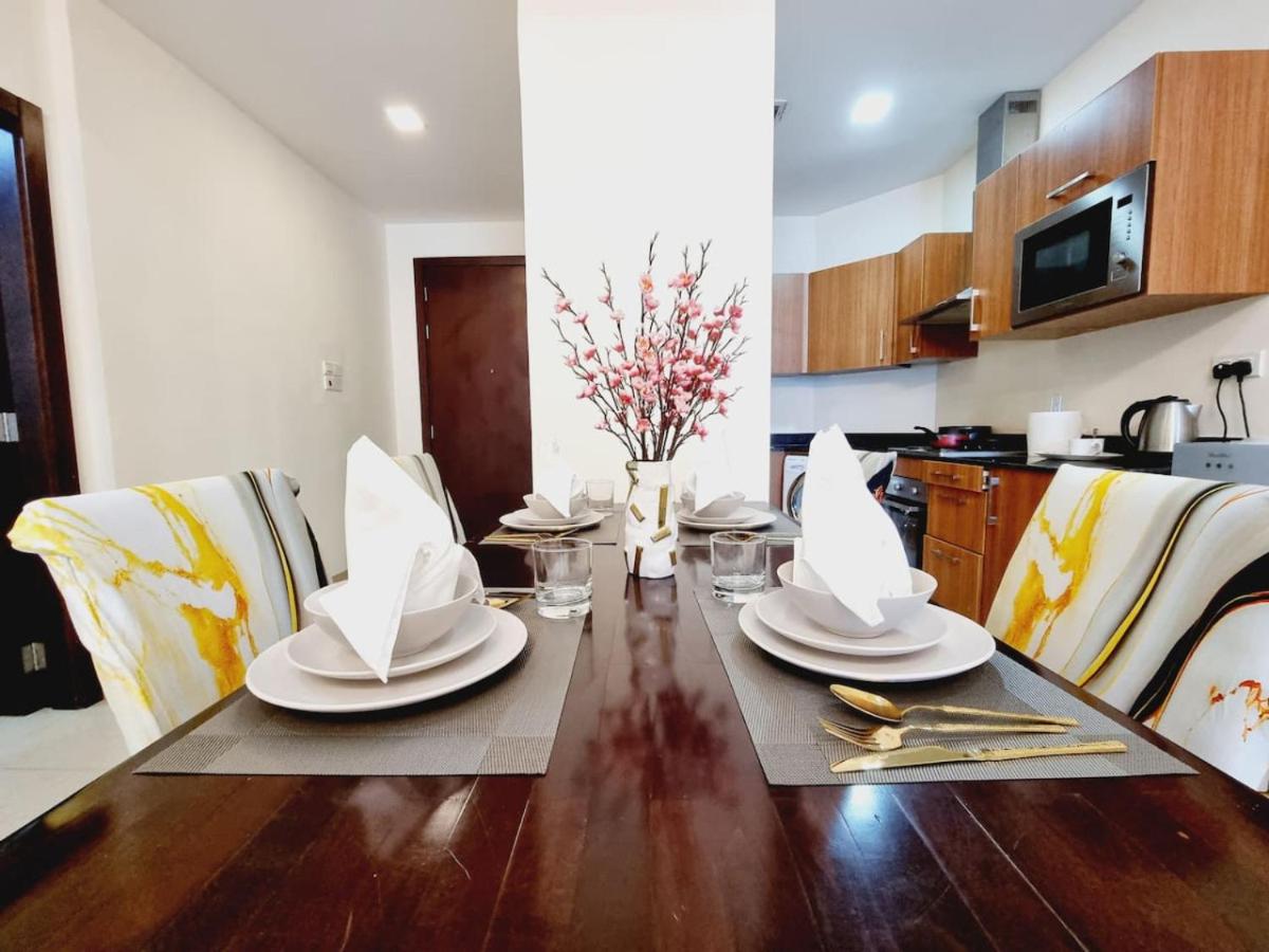 a dining room table with plates and napkins on it at Aspire Tower-Travelers Trove Juffair in Manama