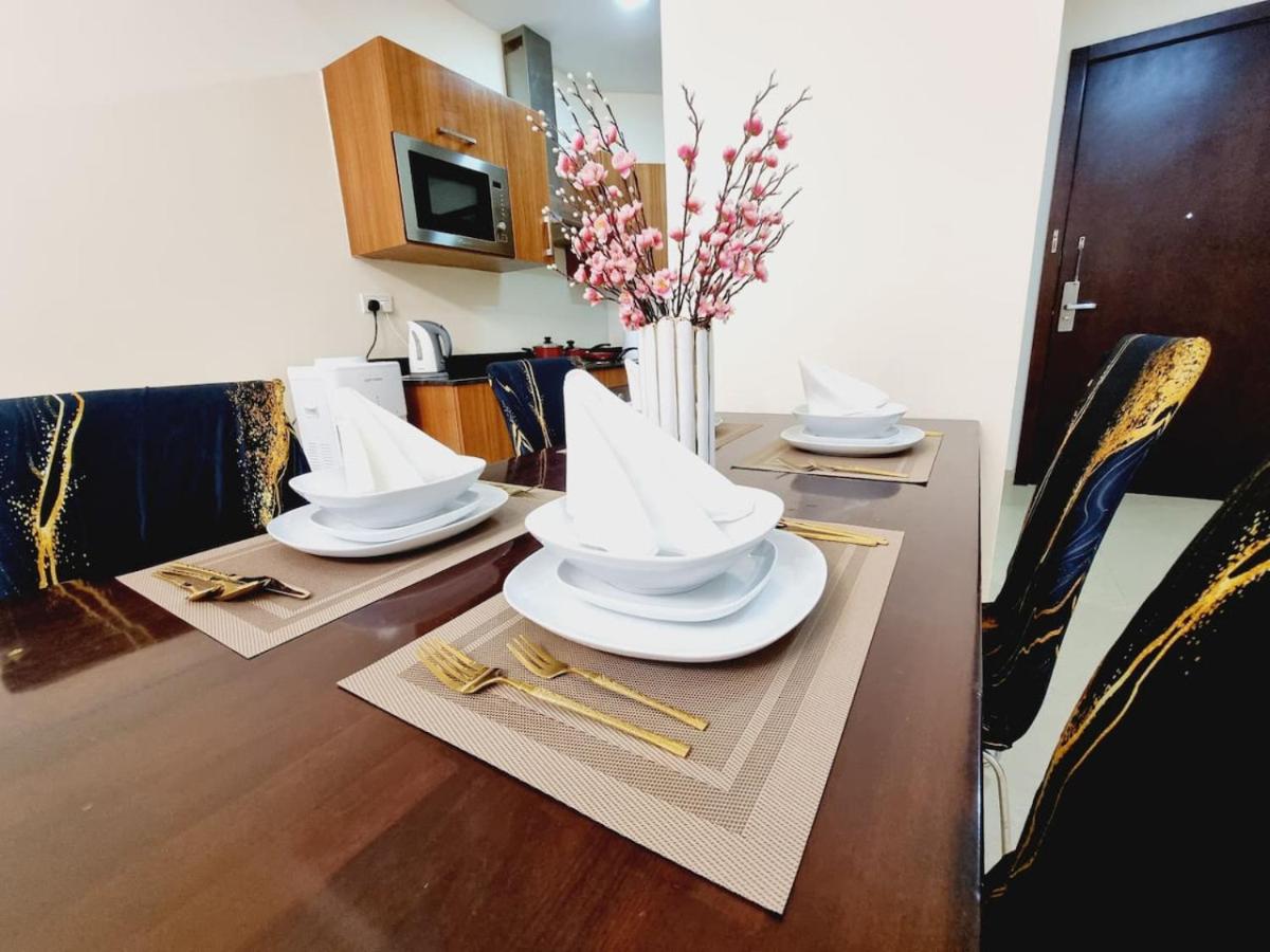 a dining room table with white plates and chopsticks at Aspire Tower-Juffair Modern Comfort Suite in Manama