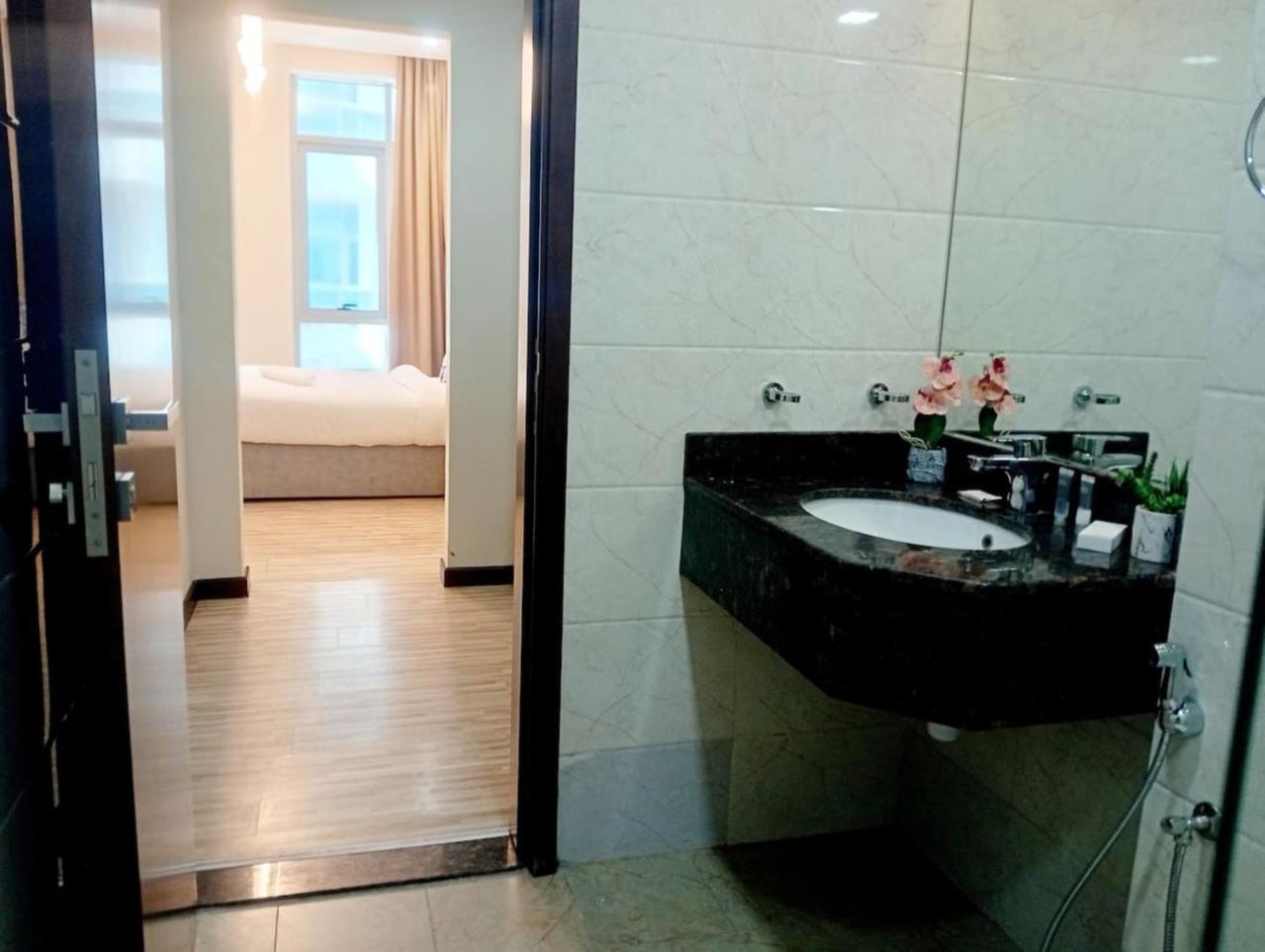 a bathroom with a black sink and a bedroom at Aspire Tower-VIP Modern Luxury Pad in Manama