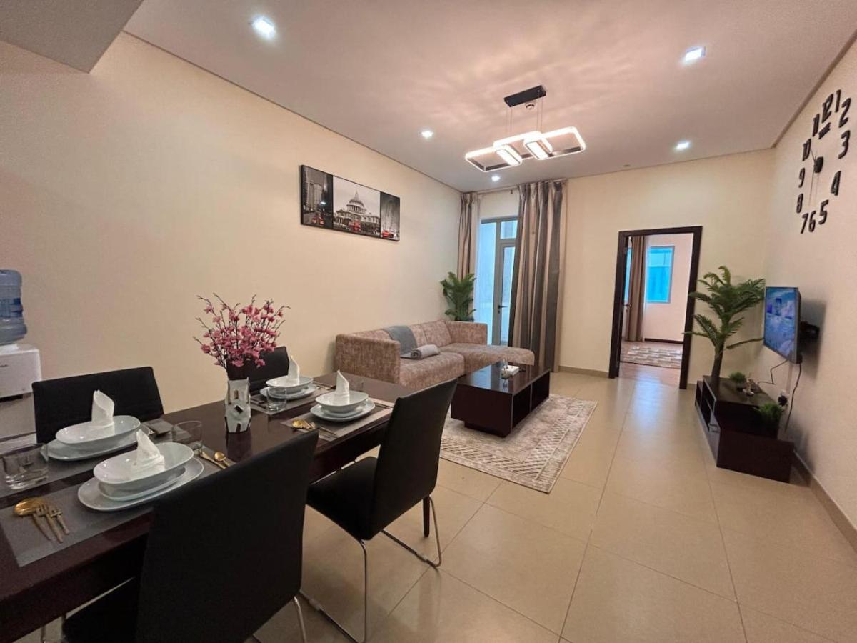 a living room with a table and a dining room at Aspire Tower-12th Floor One Bedroom Juffair in Manama