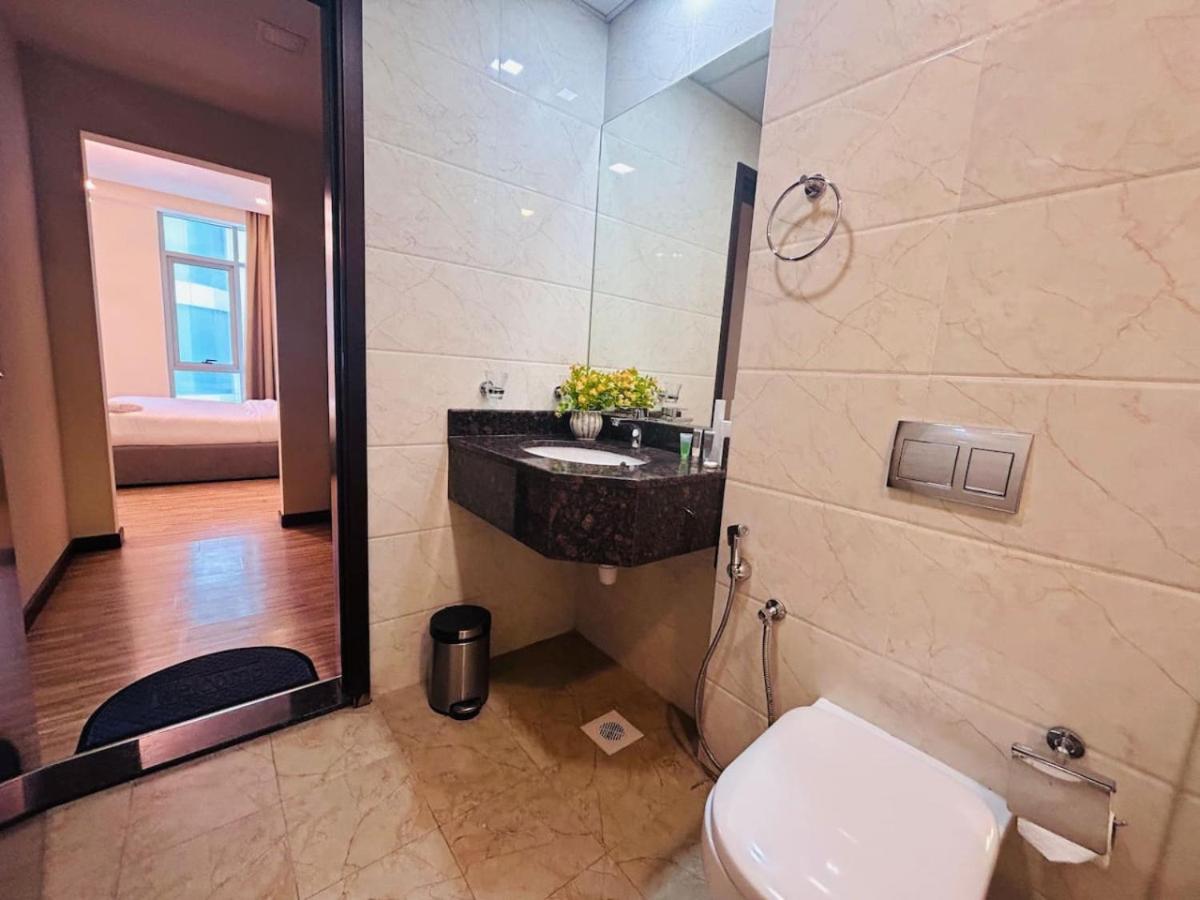 a bathroom with a toilet and a sink and a shower at Aspire Tower-12th Floor One Bedroom Juffair in Manama