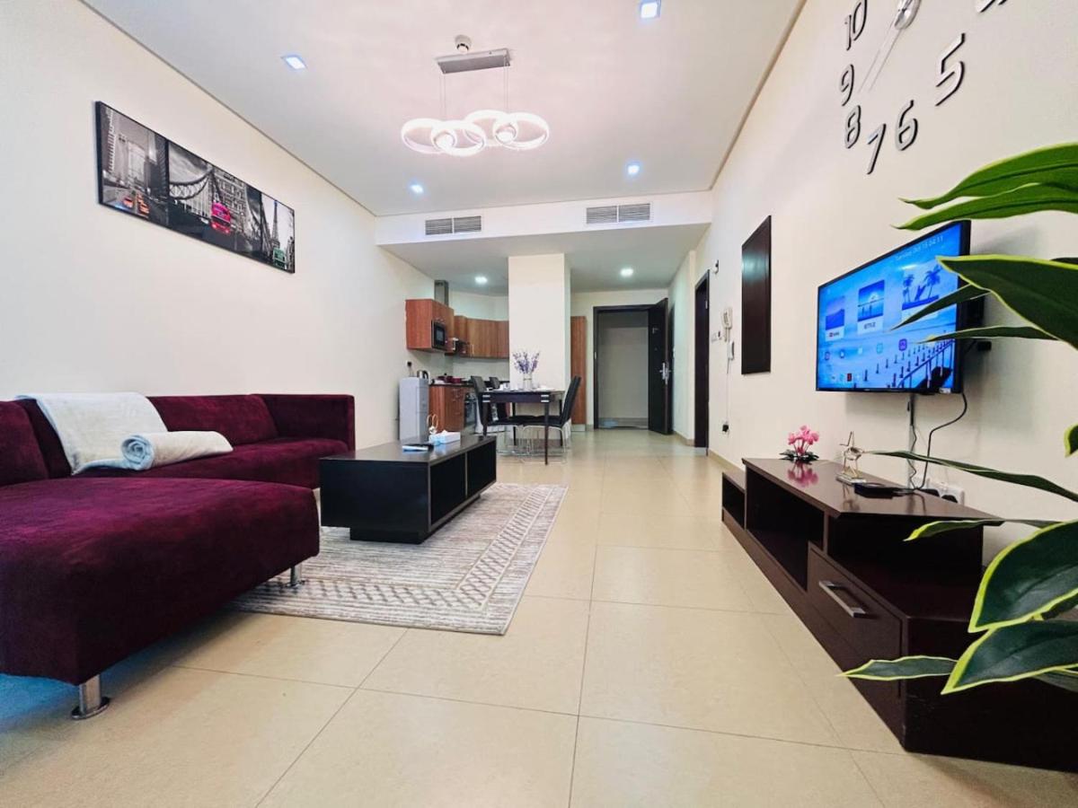 a living room with a couch and a flat screen tv at Aspire Tower -One Bedroom Quaint Nest Juffair in Manama