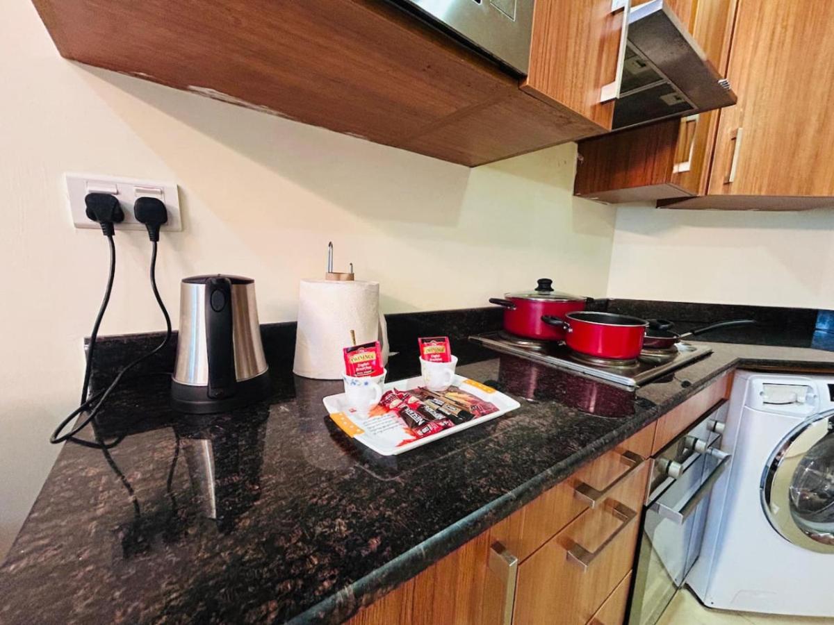 a kitchen with a counter top with pots and pans at Aspire Tower -One Bedroom Quaint Nest Juffair in Manama