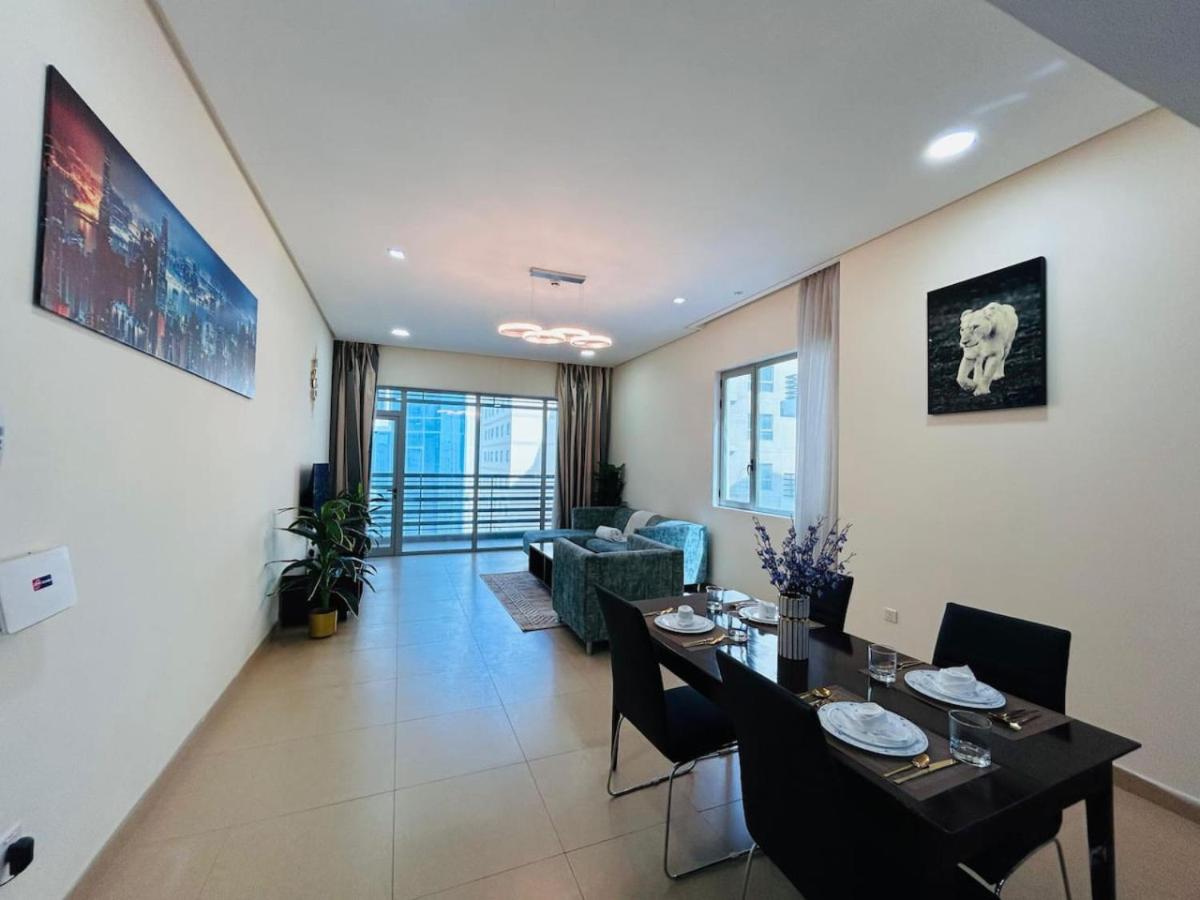 a dining room and living room with a table and chairs at Aspire Tower-Two Bedroom Retreat Juffair in Manama
