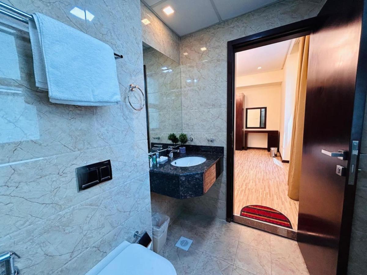 a bathroom with a sink and a toilet and a mirror at Aspire Tower-Two Bedroom Retreat Juffair in Manama