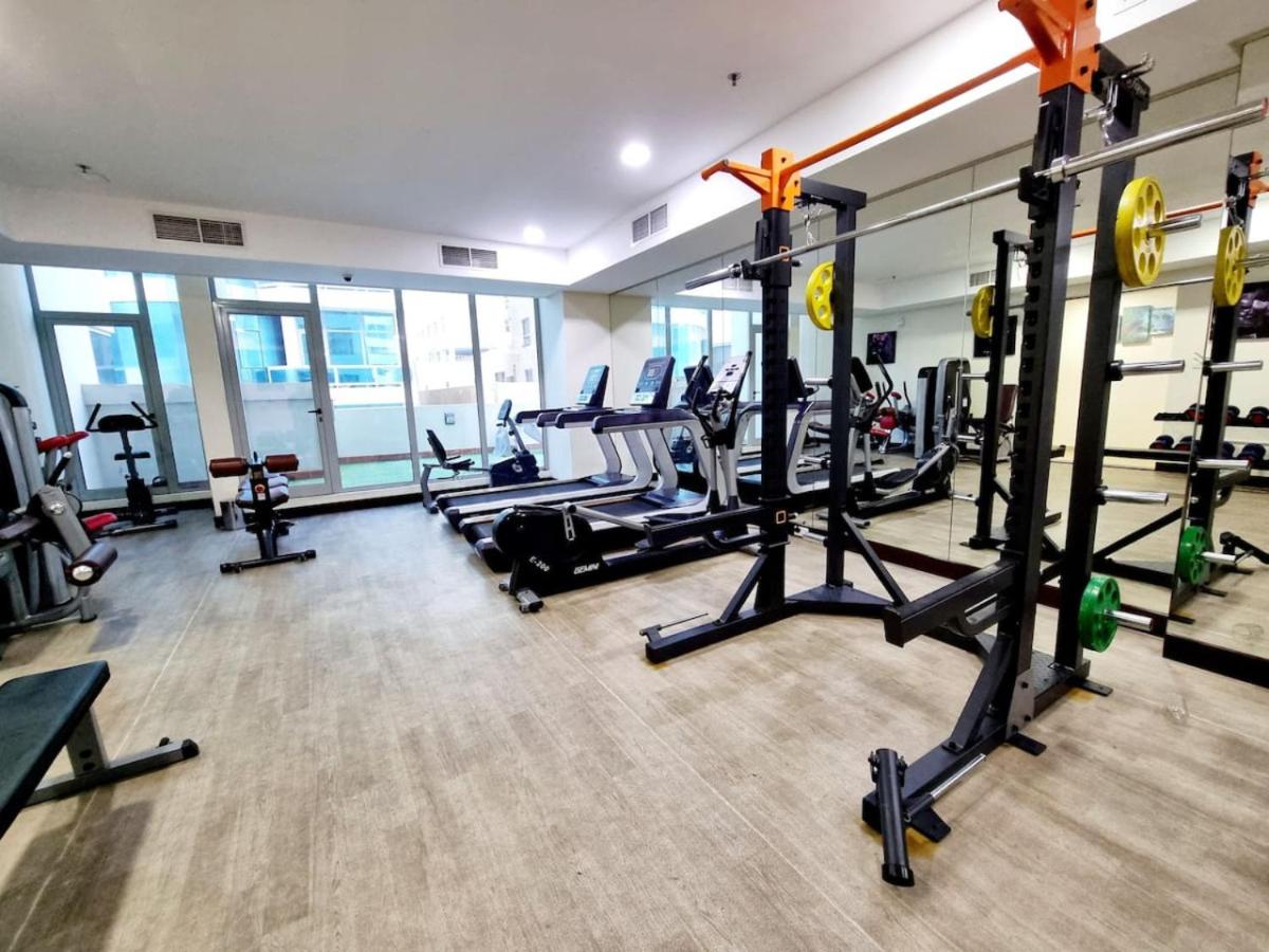 a gym with treadmills and machines in a room at Aspire Tower-One Bedroom Sunny Solo Stay in Manama