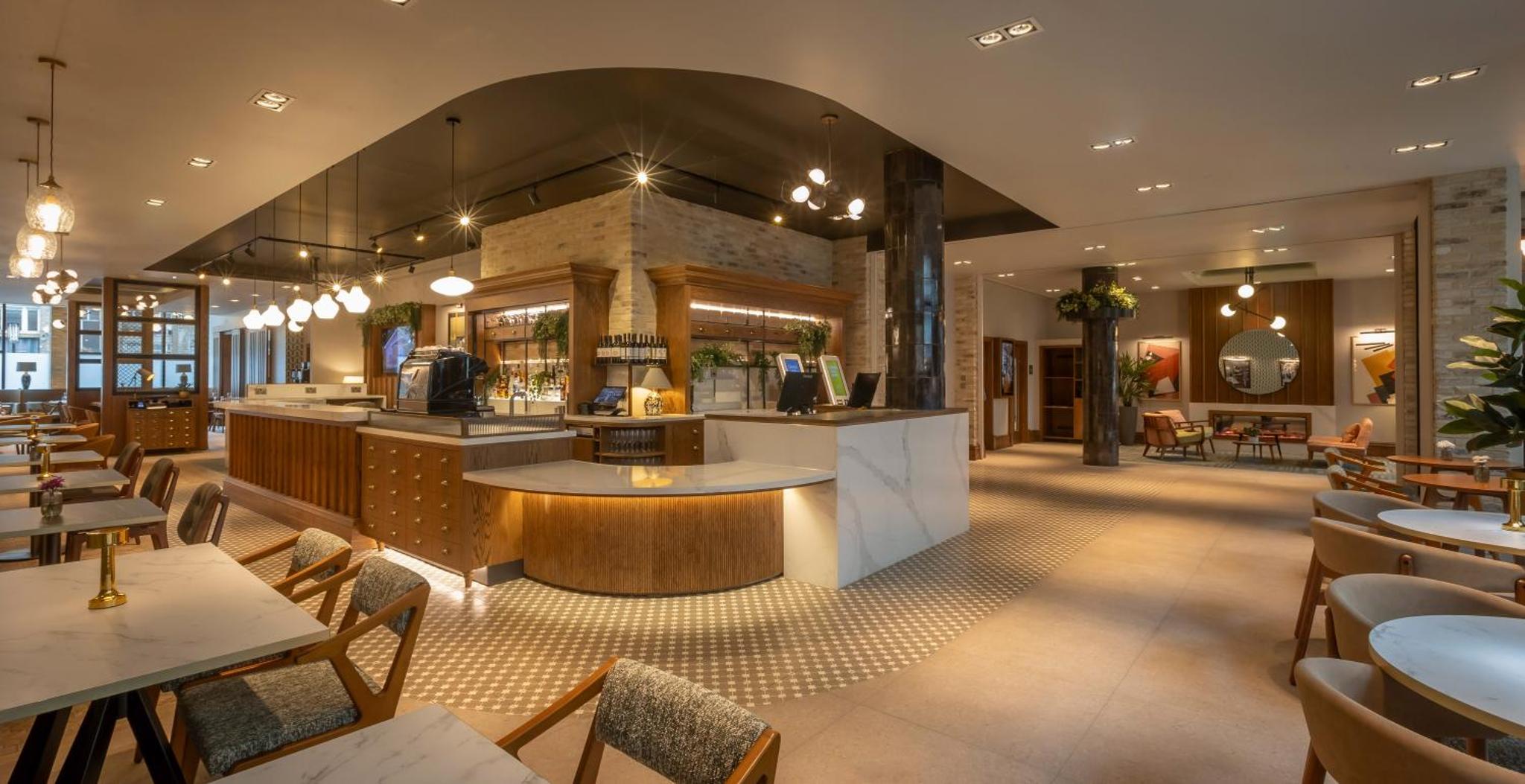 a restaurant with tables and chairs and a bar at Maldron Hotel Shoreditch London in London