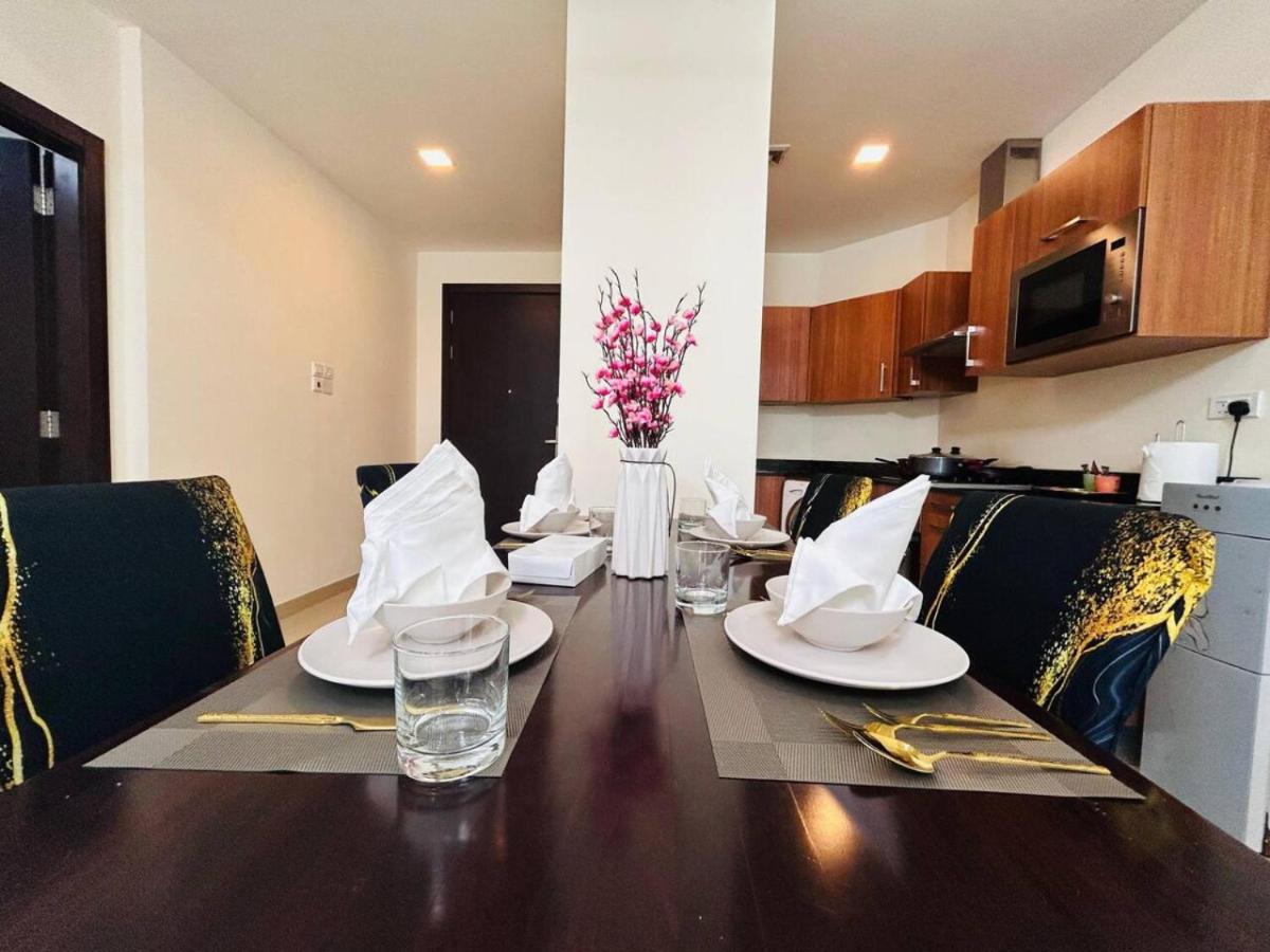 a dining room table with chairs and a vase of flowers at Aspire Tower -Skyline Retreat Juffair in Manama