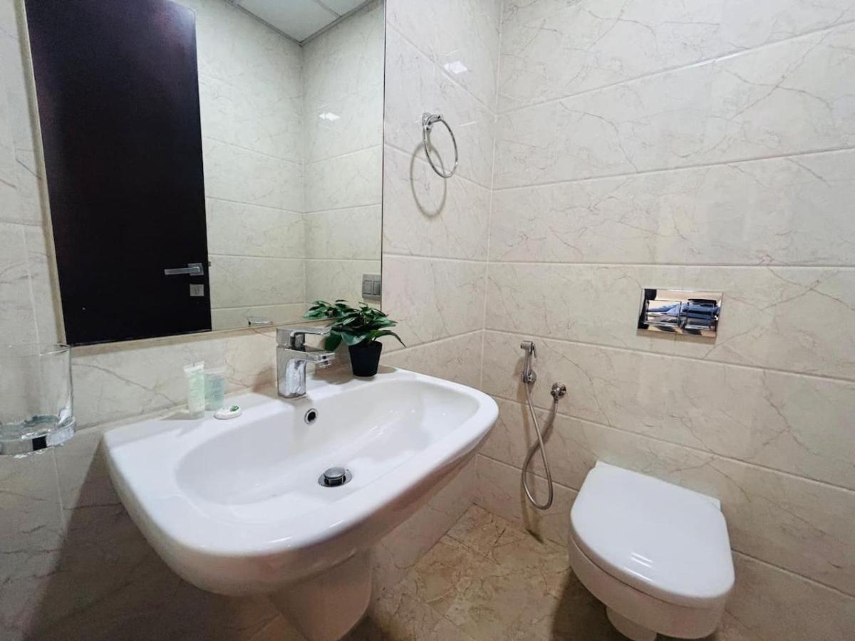 a white bathroom with a sink and a toilet at Aspire Tower -Skyline Retreat Juffair in Manama +11 photos