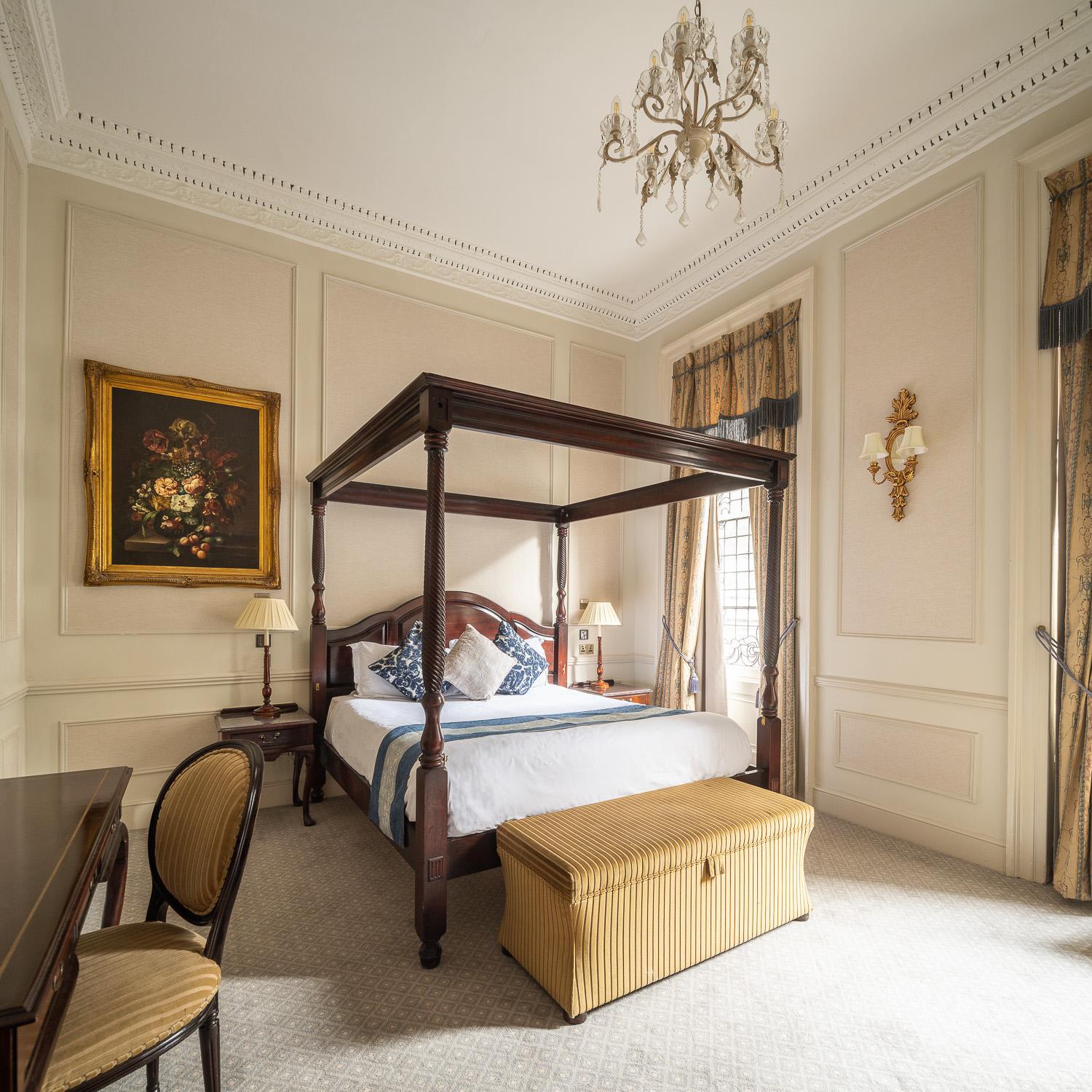 a bedroom with a canopy bed and a chair at The Leonard Hotel in London