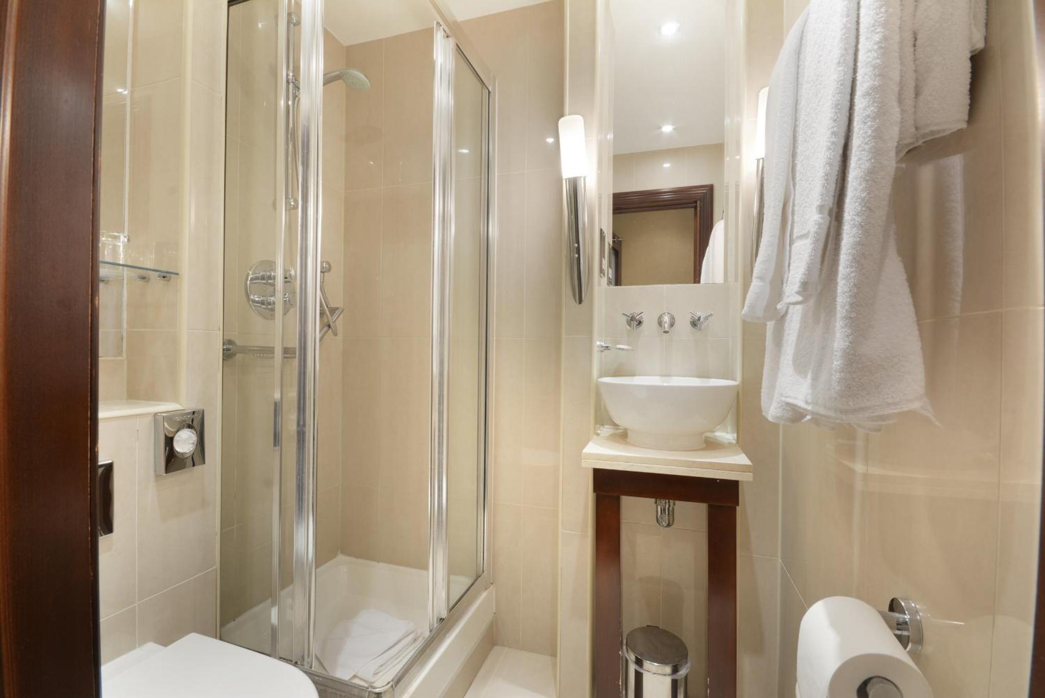 a bathroom with a shower and a toilet and a sink at The Premier Notting Hill in London +41 photos