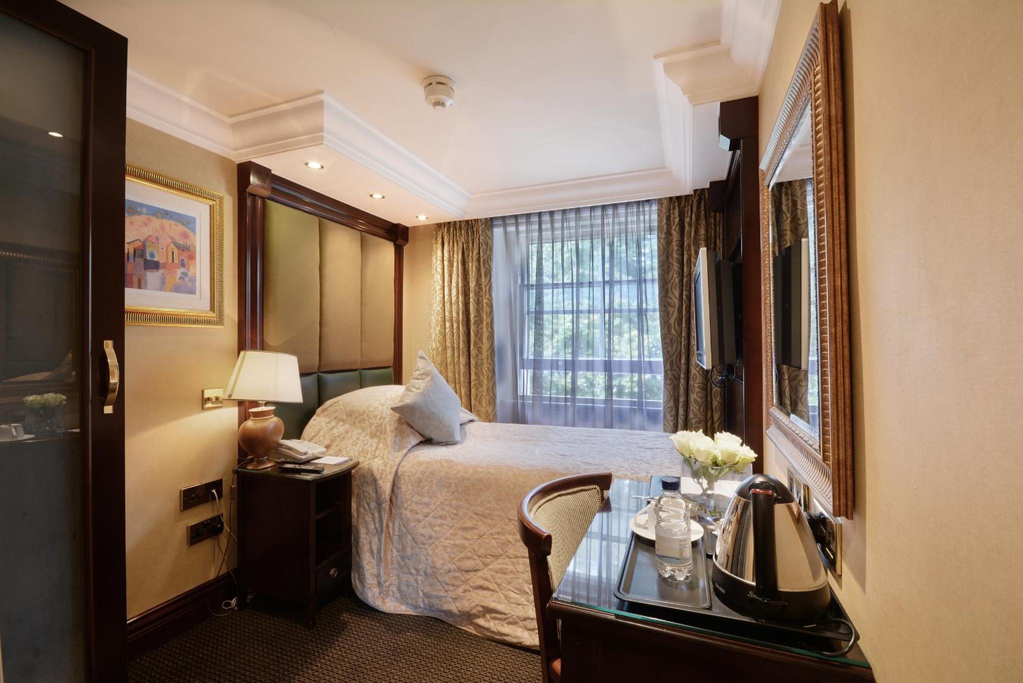 a hotel room with a bed and a table at The Premier Notting Hill in London
