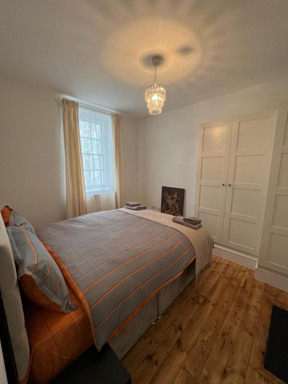 a bedroom with a bed and a chandelier at 1 Bed Apartment - Centrally Located In The Heart of Westminster in London
