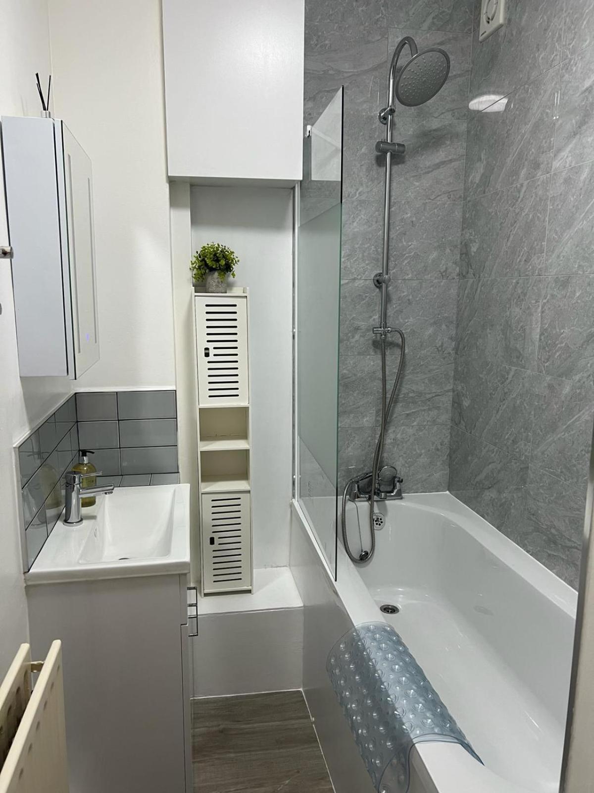 a bathroom with a shower and a tub and a sink at 1 Bed Apartment - Centrally Located In The Heart of Westminster in London