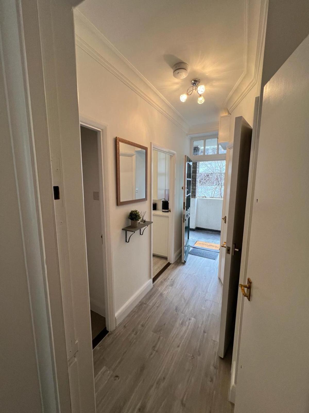 a hallway of a home with white walls and wood floors at 1 Bed Apartment - Centrally Located In The Heart of Westminster in London