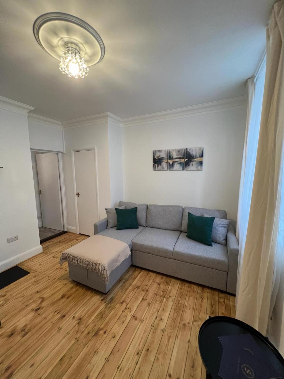 a living room with a couch and wooden floors at 1 Bed Apartment - Centrally Located In The Heart of Westminster in London