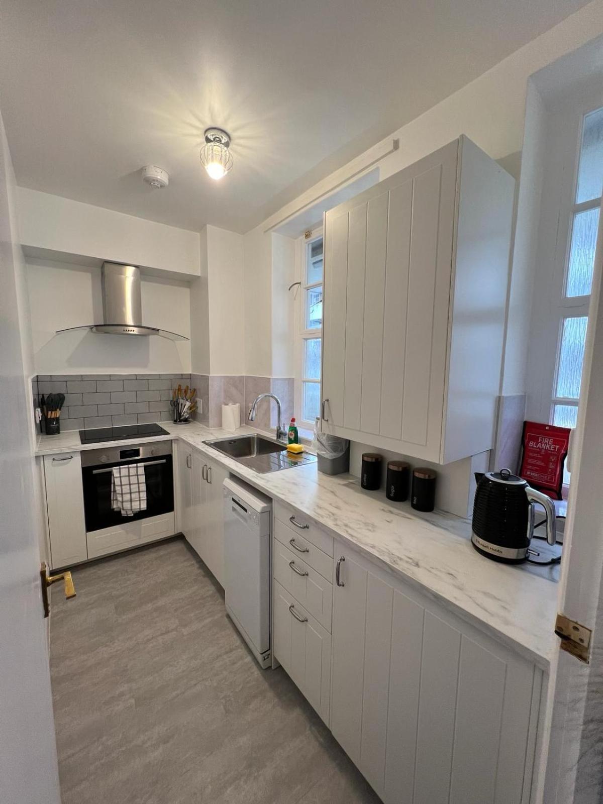 a kitchen with white cabinets and a sink at 1 Bed Apartment - Centrally Located In The Heart of Westminster in London