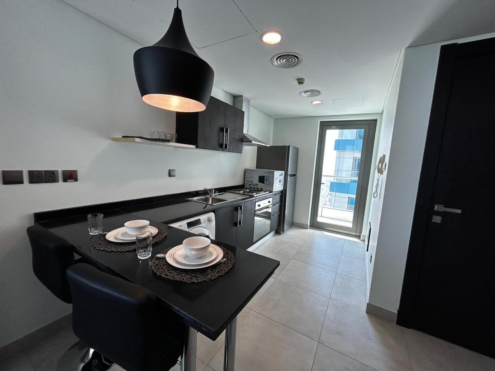 a kitchen with a table with plates on it at Holiday Homes- Apartment in Manama