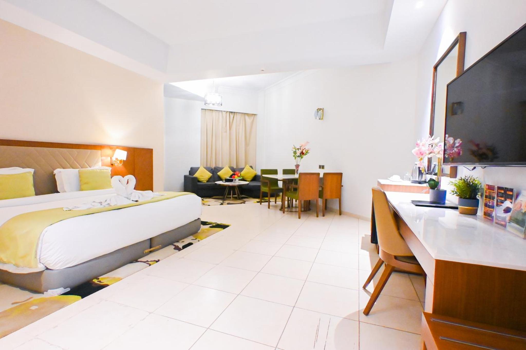 a large hotel room with a bed and a television at Ramee Palace Hotel in Juffair +138 photos