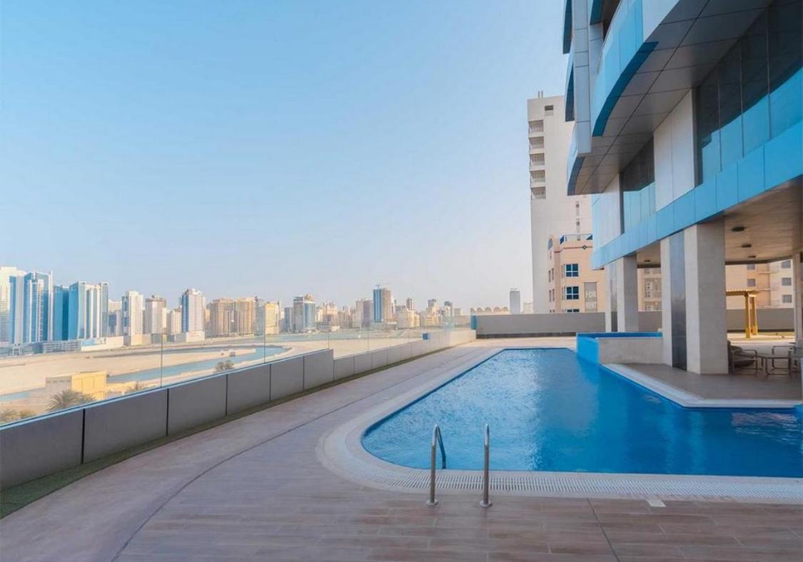 a swimming pool on the roof of a building at Holiday Homes- Apartment in Manama