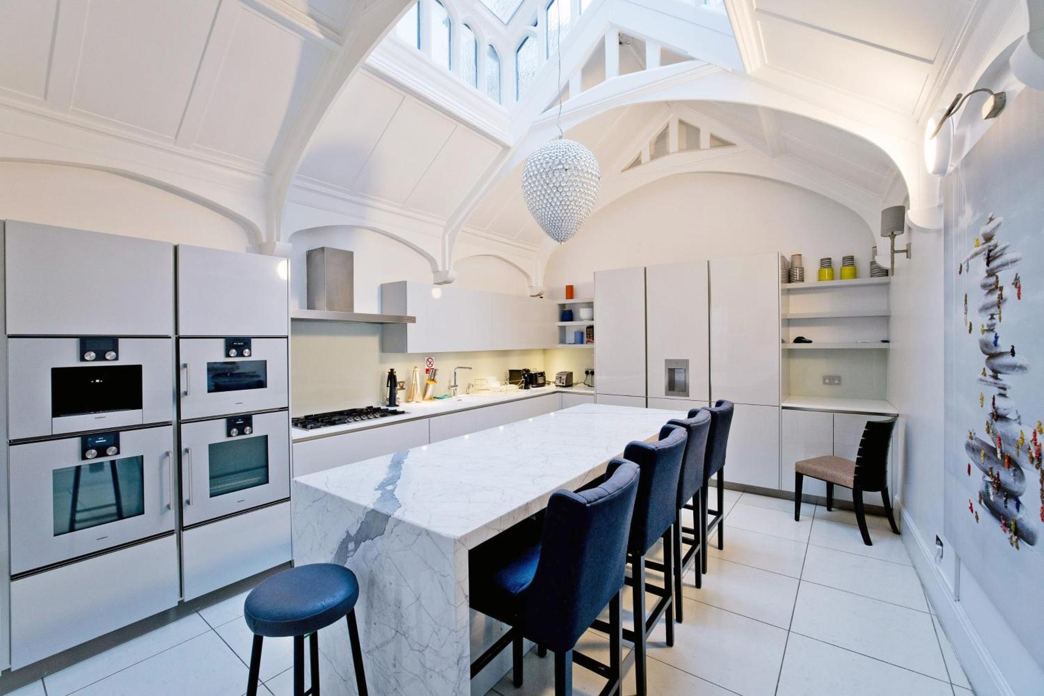 a kitchen with a large marble table and chairs at Imperial Victoria Square in London