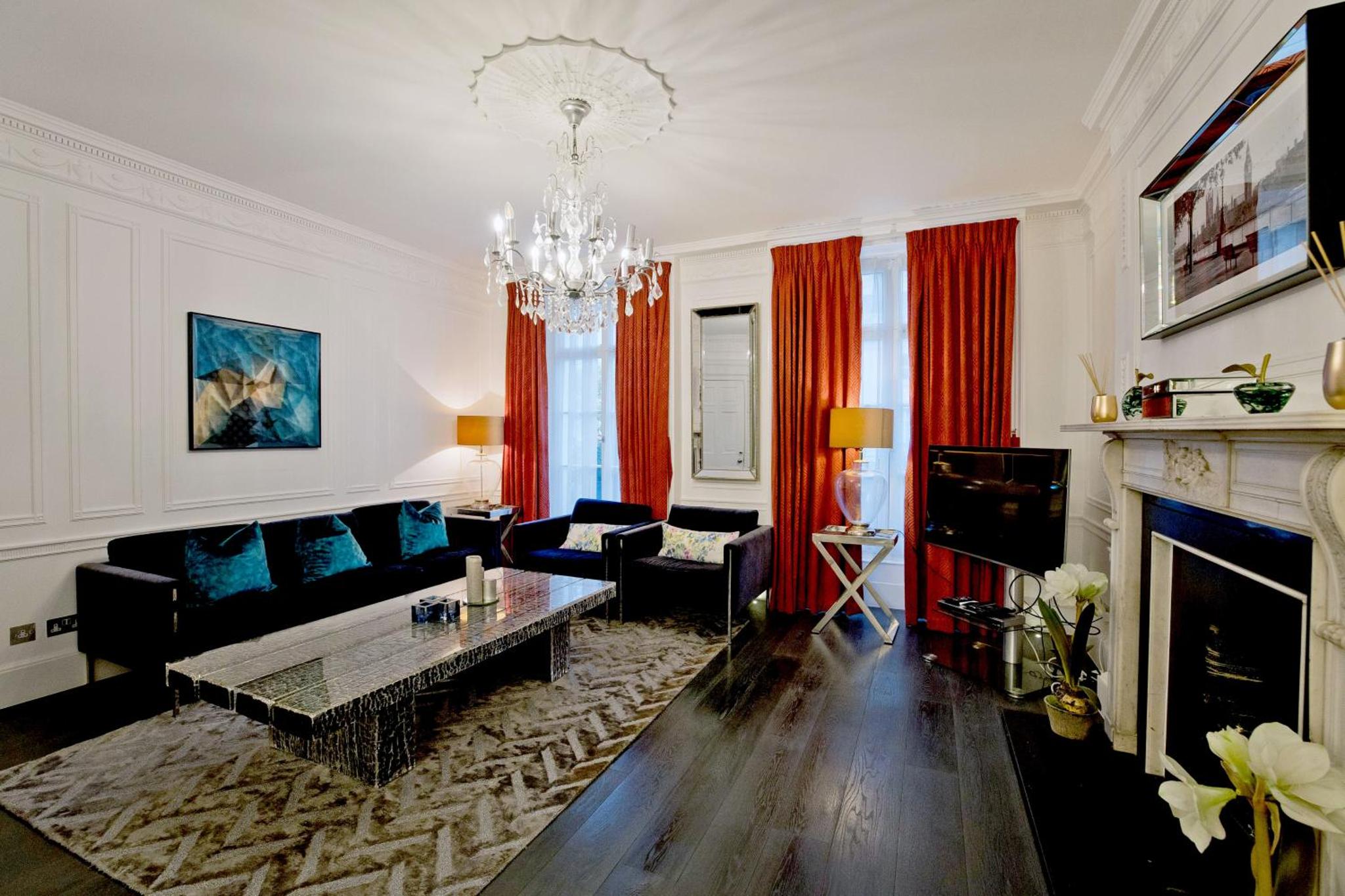 a living room with a couch and a fireplace at Imperial Victoria Square in London