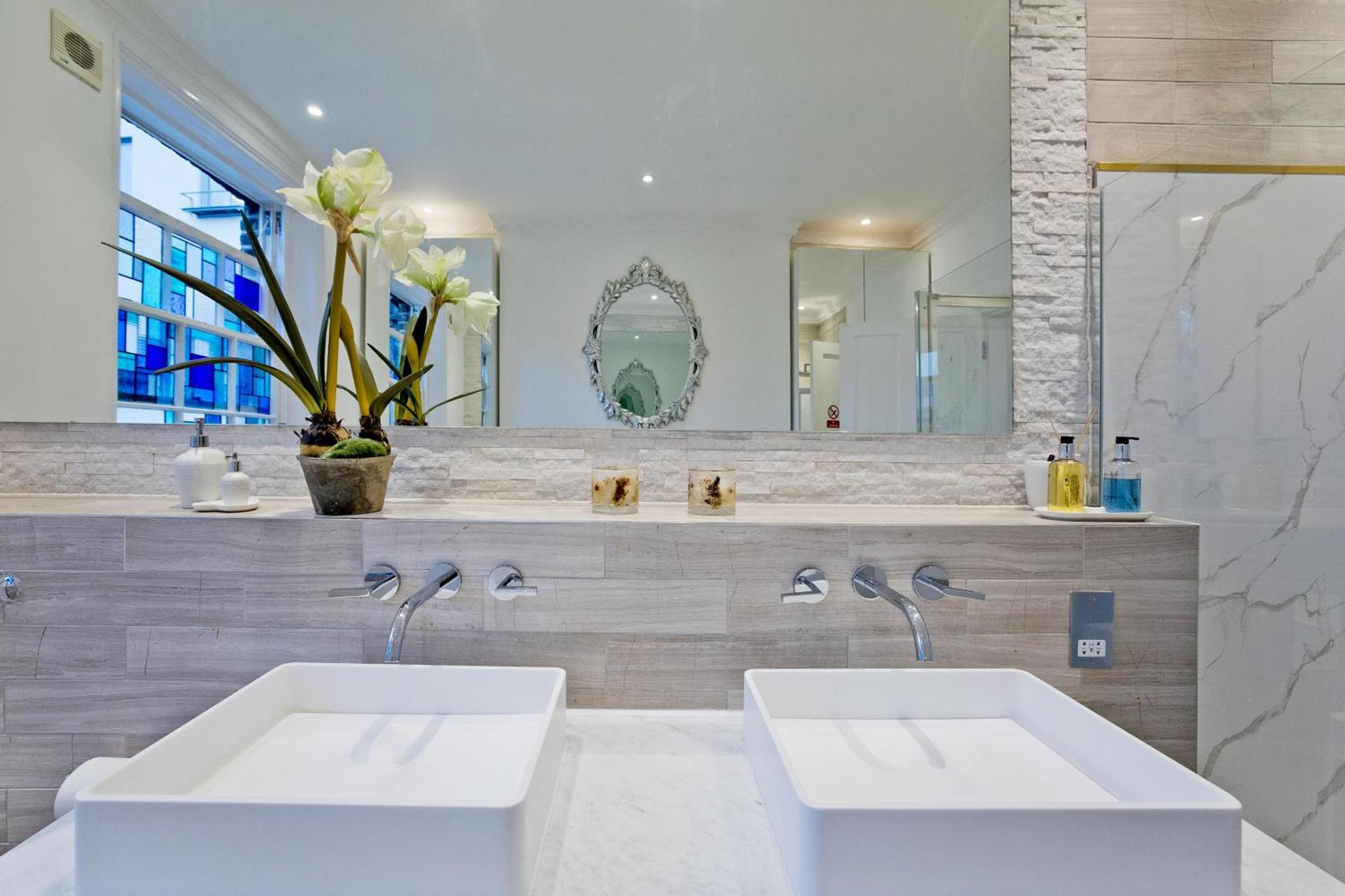 a bathroom with two sinks and a large mirror at Imperial Victoria Square in London +136 photos