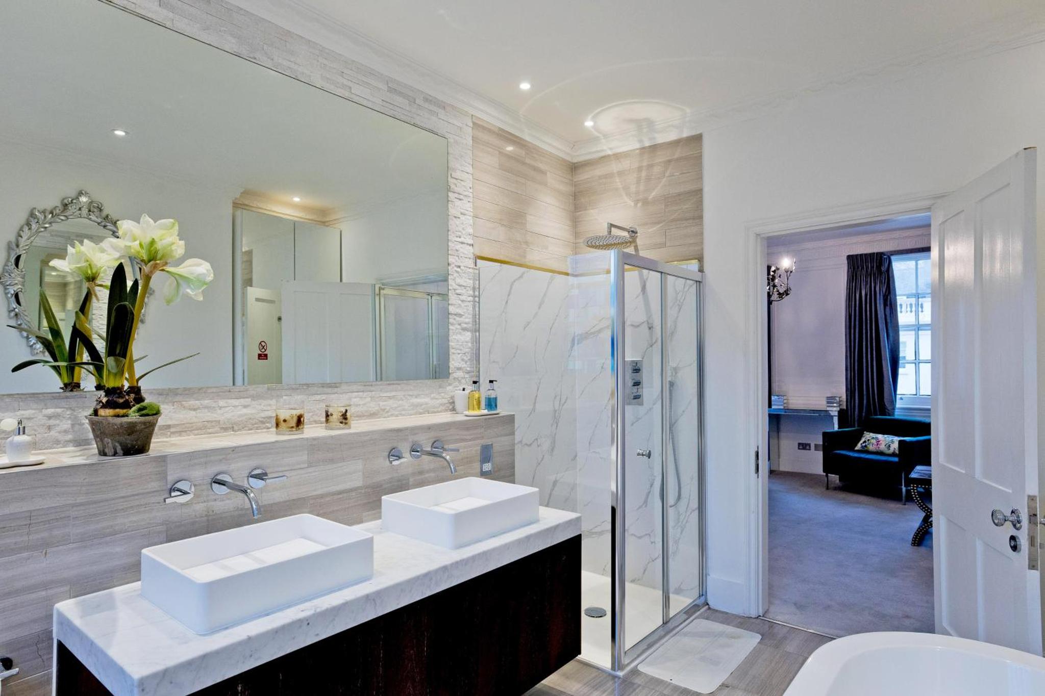 a bathroom with two sinks and a large mirror at Imperial Victoria Square in London